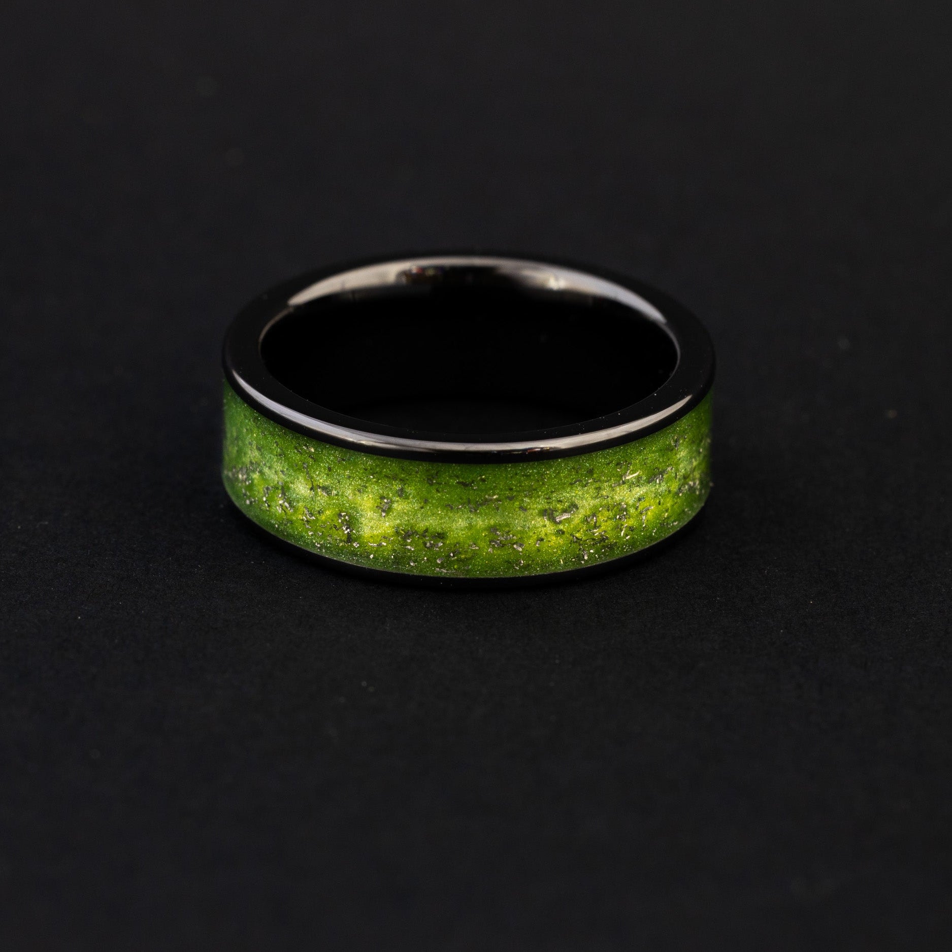 Close up of Campo del Cielo meteorite shavings in a vibrant lime green 8mm ceramic ring.