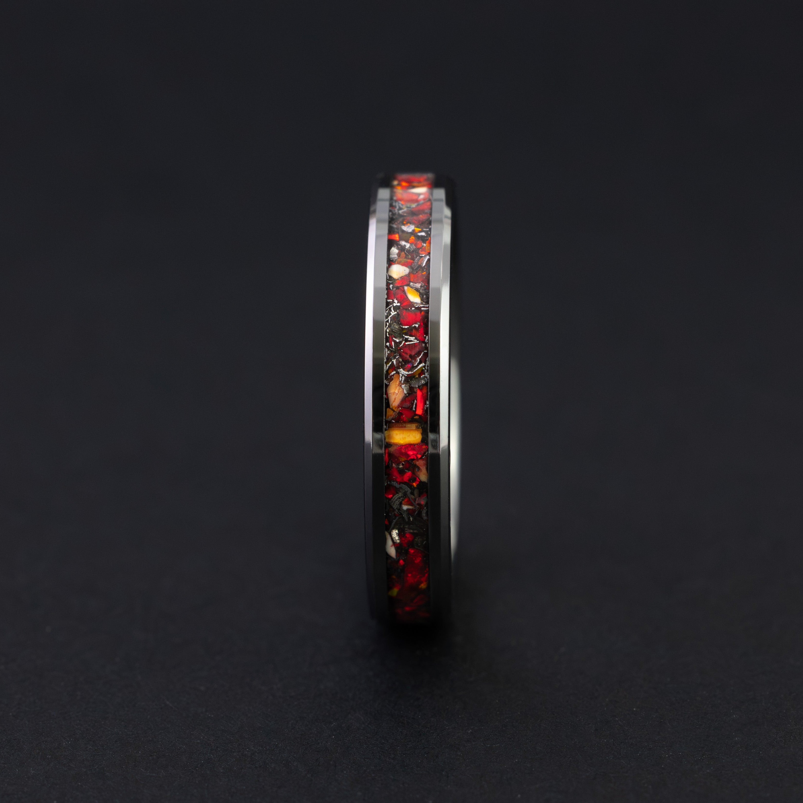Close up of genuine Velociraptor fossil and meteorite in a thin black ceramic ring.