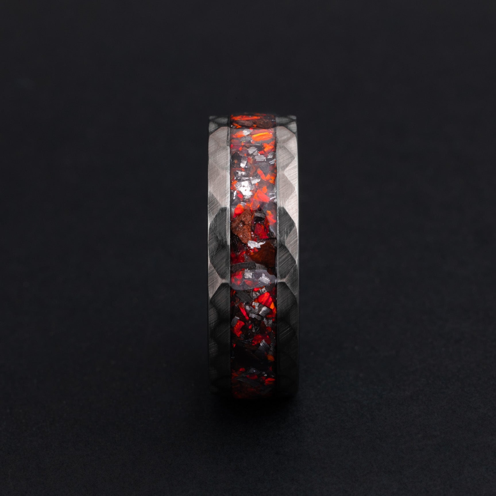 Detailed view of genuine T-Rex fossil shards and meteorite in a hammered silver tungsten ring.