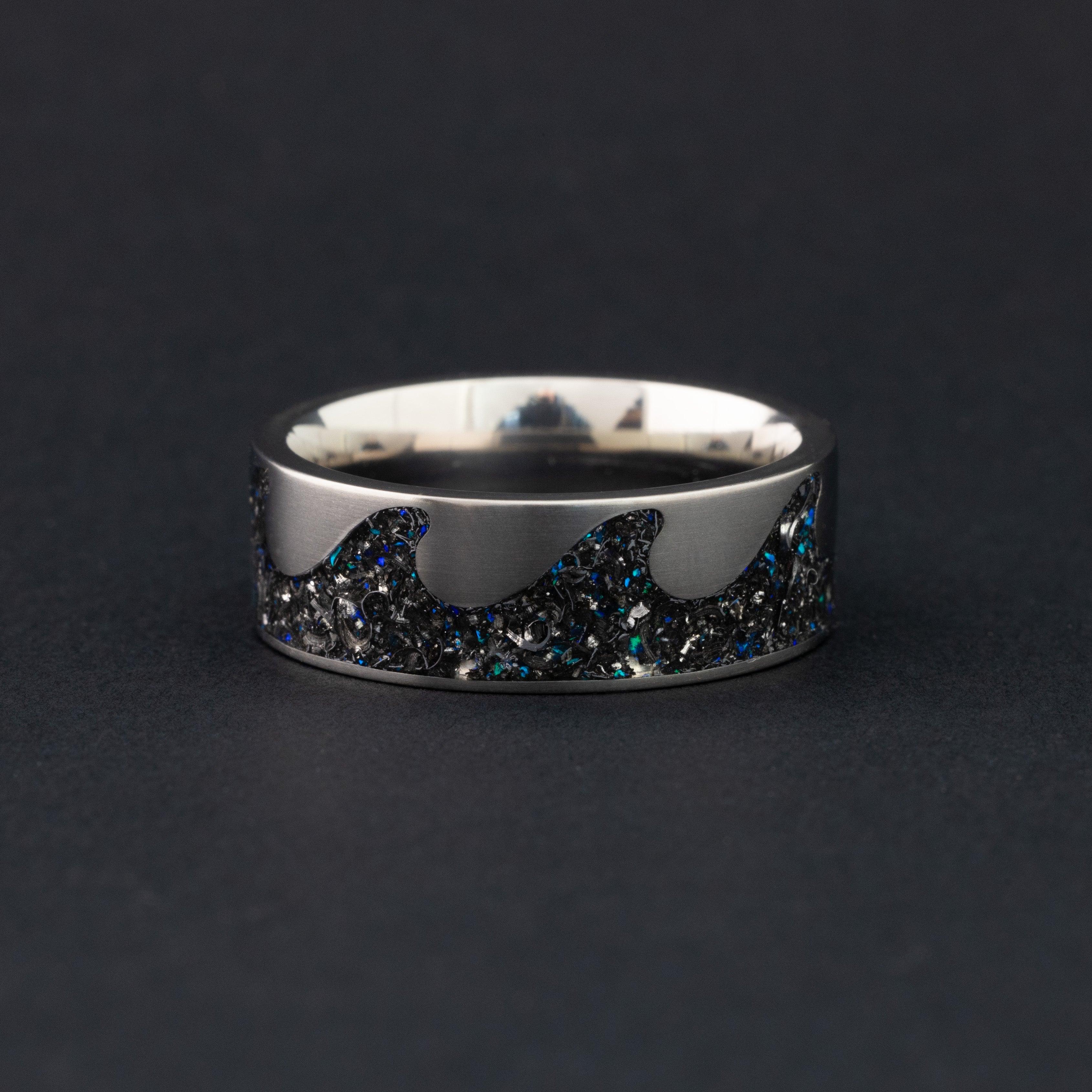 Detail shot of the Blue Meteorite Riptide ring showing authentic Campo del Cielo meteorite pieces and blue opal accents in the wave-shaped titanium riptide channel