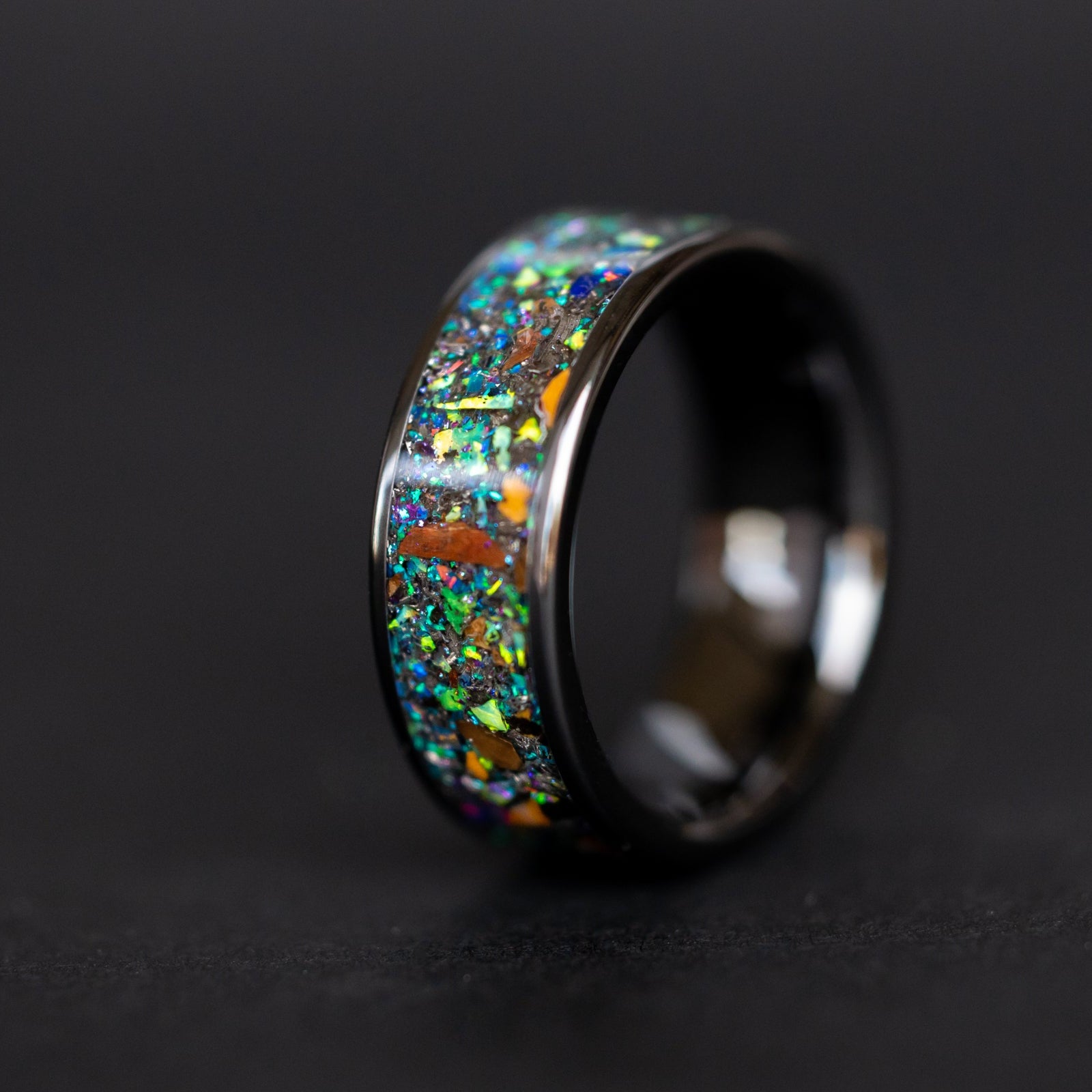 8mm wide channel black ceramic ring with authentic T-Rex and Velociraptor bone and Campo del Cielo meteorite in blue and green galaxy opal inlay