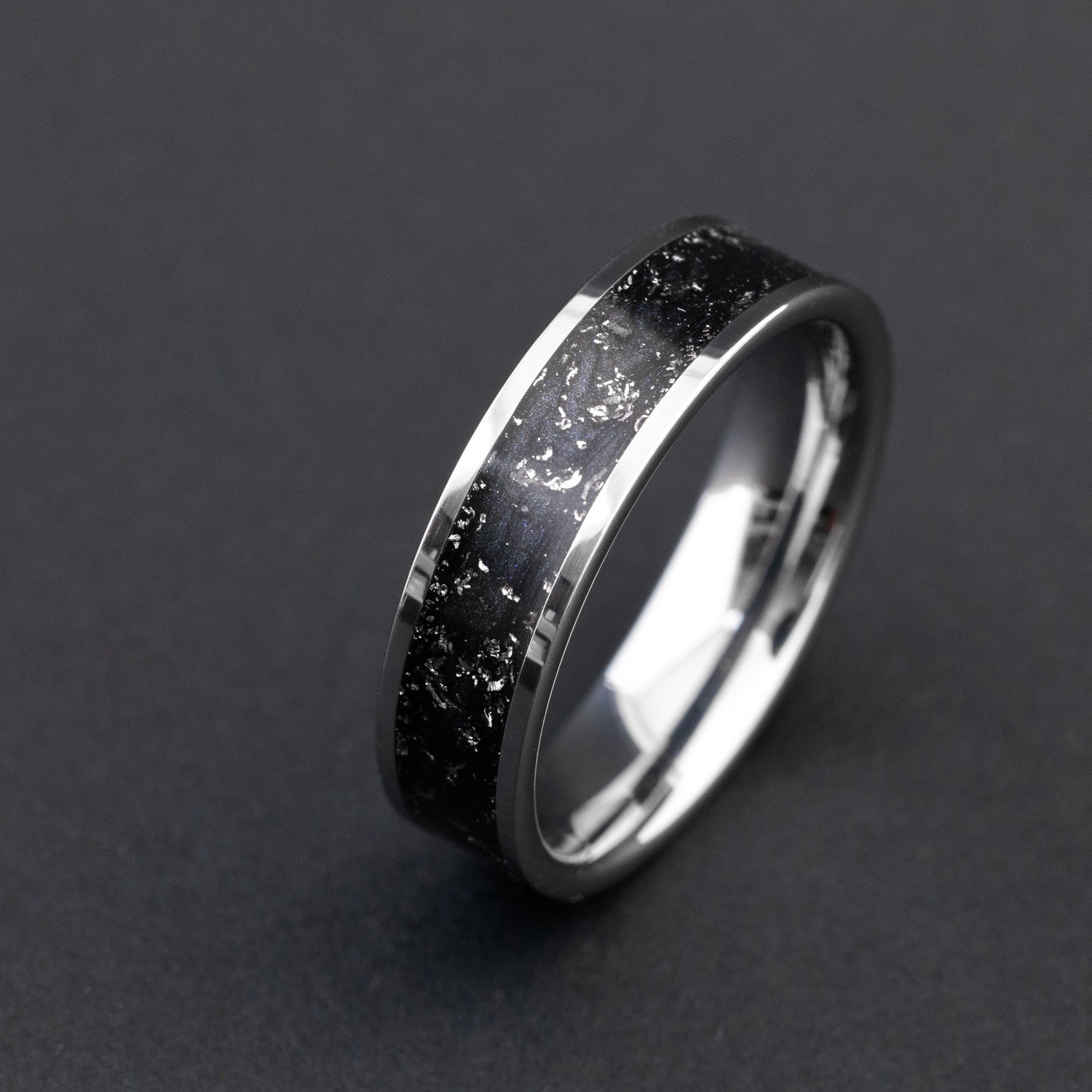 Close up of Gibeon meteorite shavings in a sleek black 6mm tungsten ring.