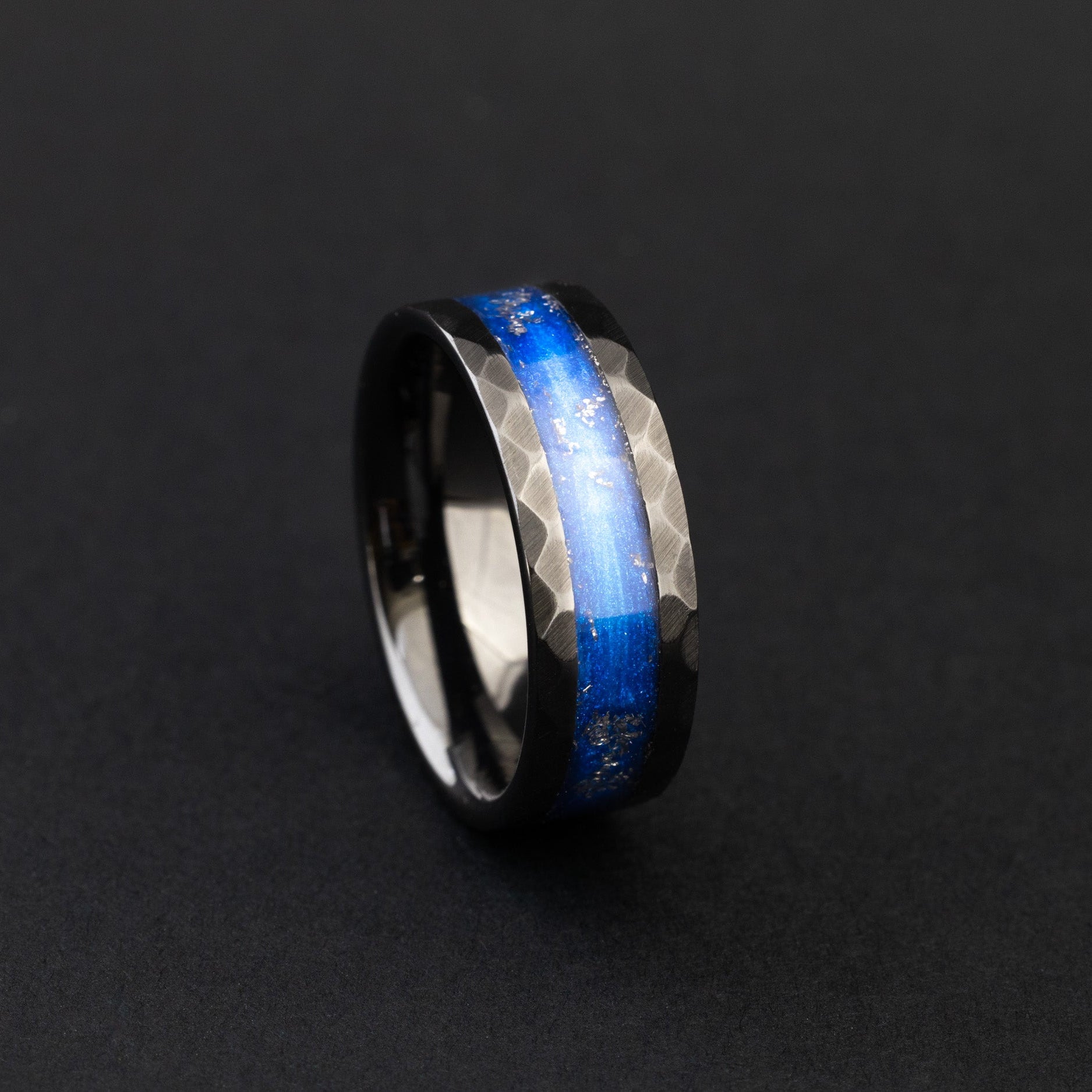 Close up of Campo del Cielo meteorite shavings in a vibrant blue hammered ceramic ring.