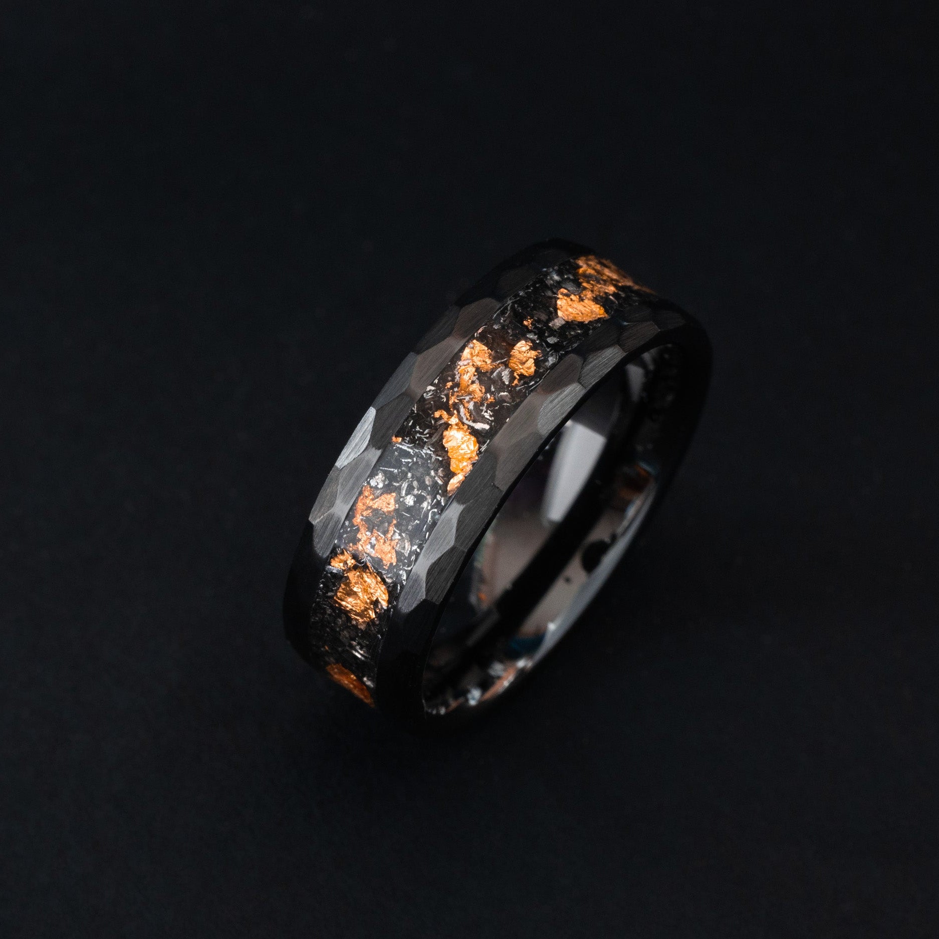 hammered black ceramic wedding band featuring celestial meteorite fragments and copper inlay.