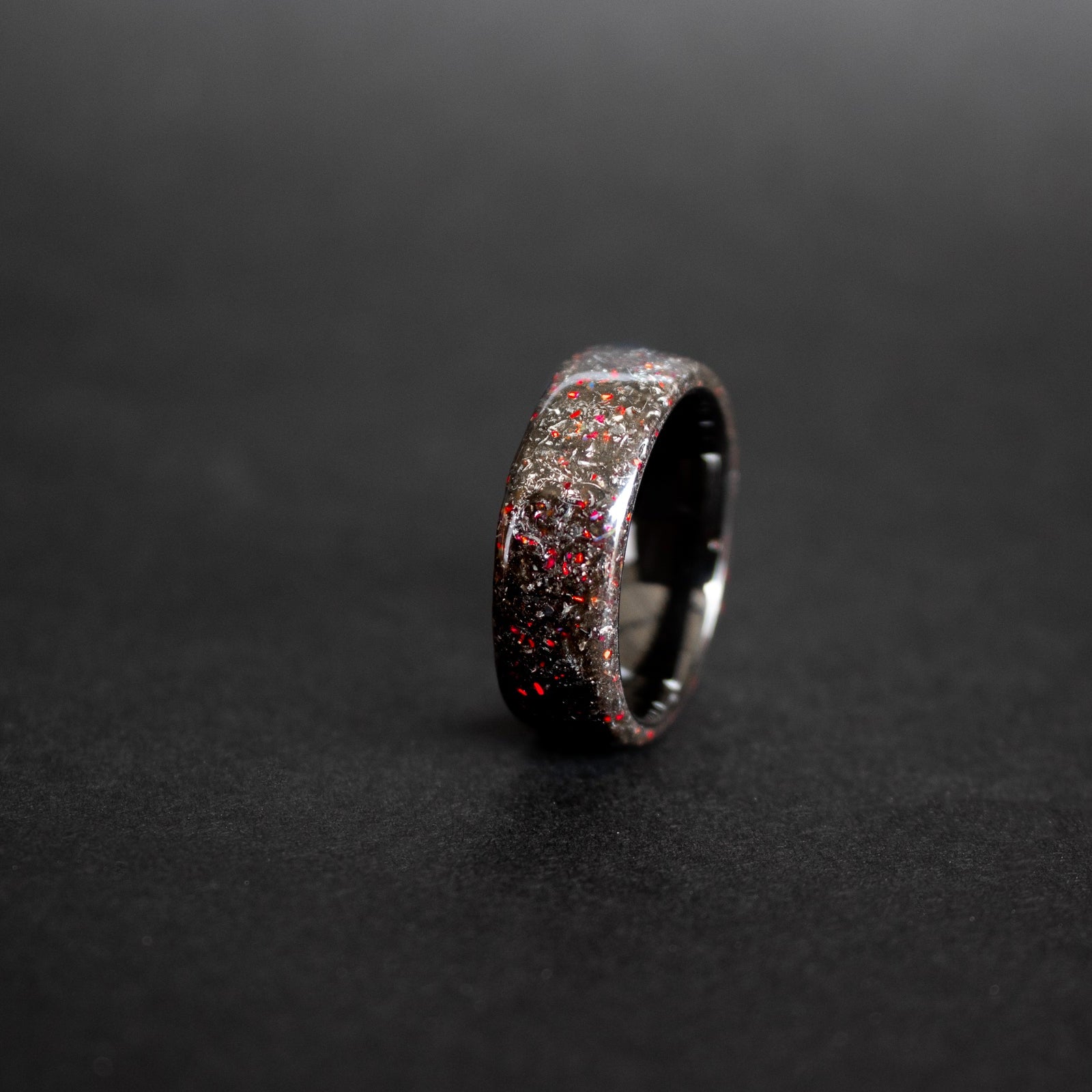 Endless black ceramic ring with authentic Campo del Cielo meteorite shavings and red opal accents