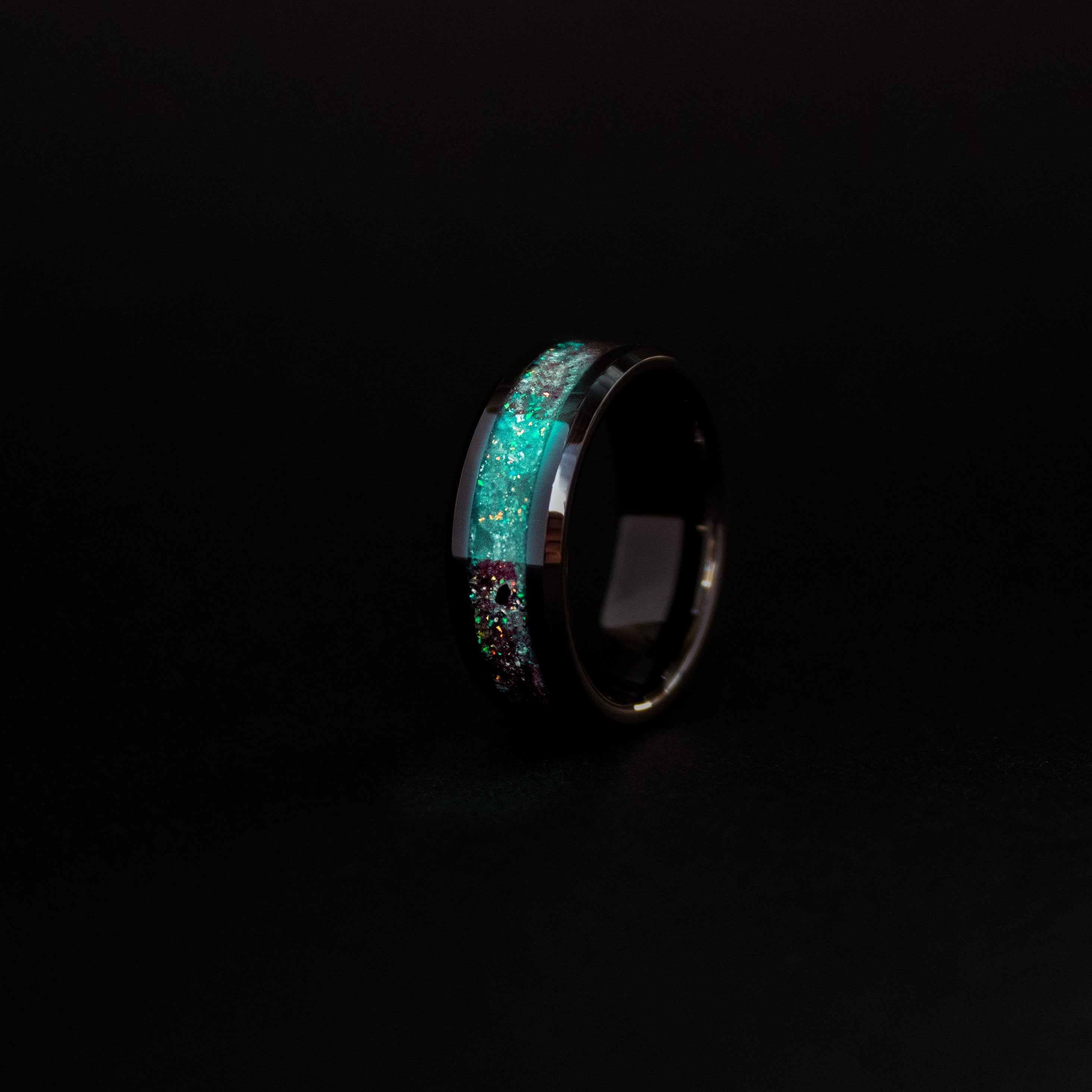 8mm beveled black ceramic ring with authentic Megalodon tooth and Campo del Cielo meteorite in blue and green opal inlay glowing teal in the dark
