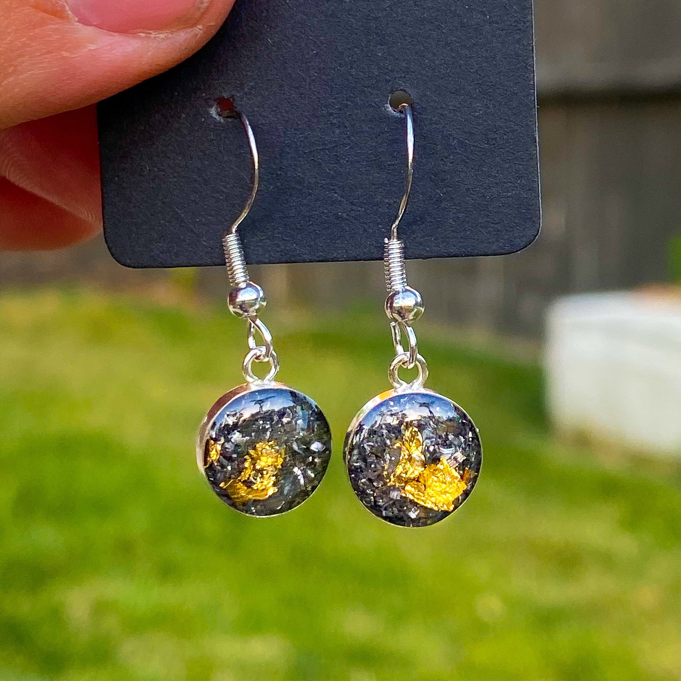 Close-up of the Gold Comet Dangle drop earrings showing Campo Del Cielo iron meteorite layered with bright gold leaf in sterling silver