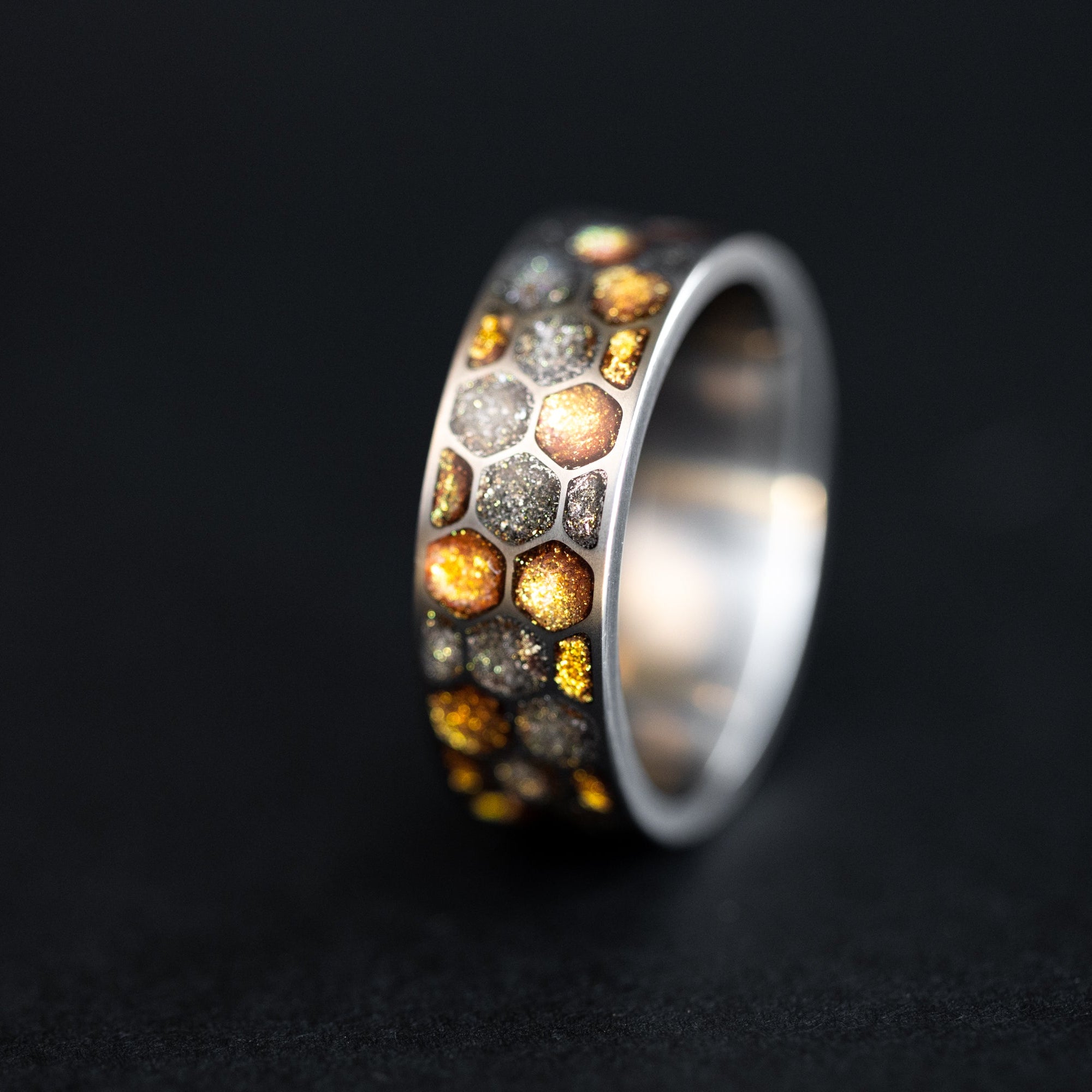 Titanium Golden Honeycomb ring with gold resin and meteorite inlay in a honeycomb pattern.