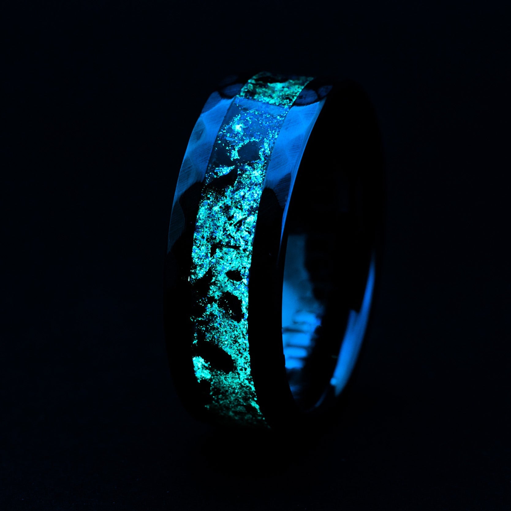 Close up of Megalodon tooth and Campo meteorite shavings in a hammered black ceramic ring.