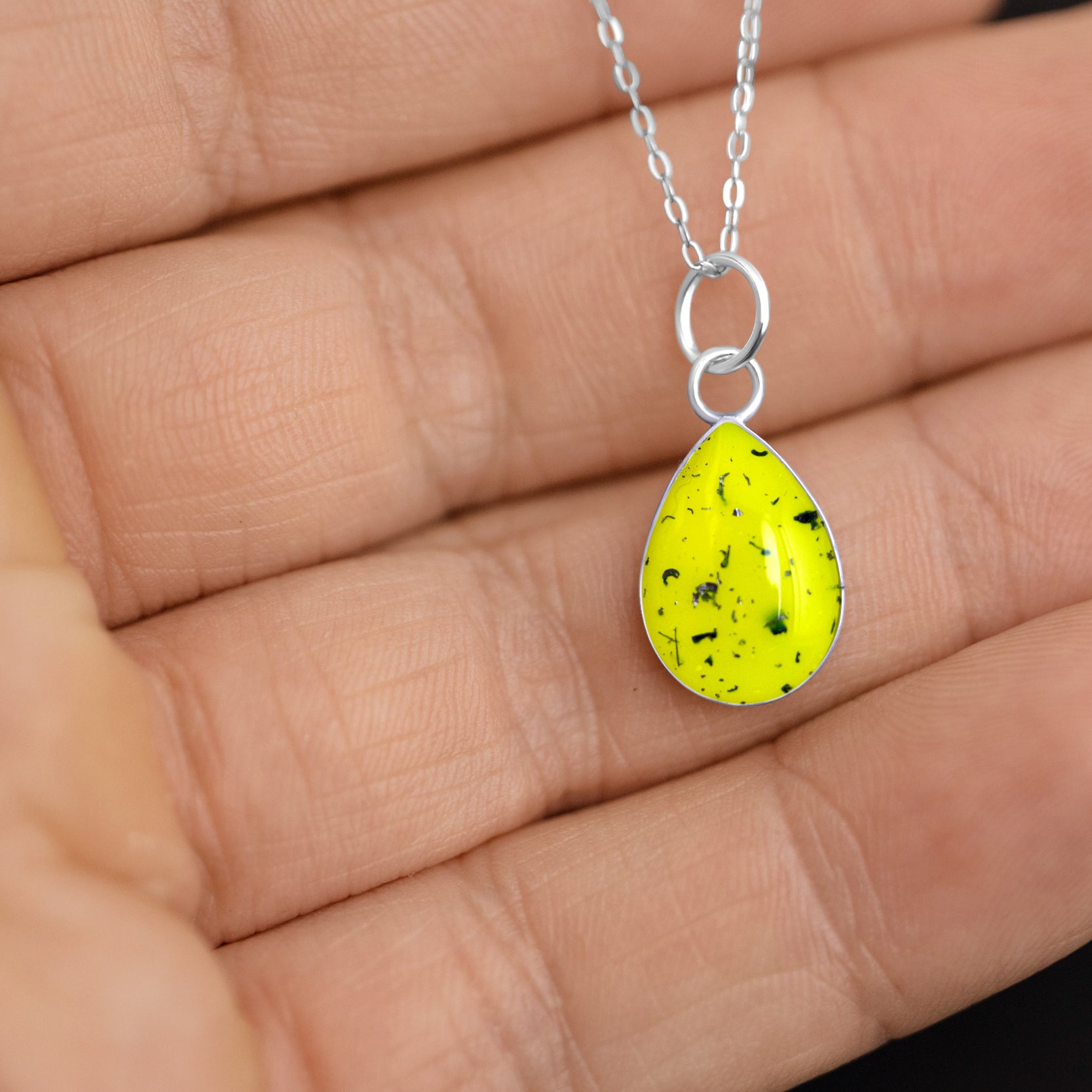 Handcrafted sterling silver teardrop pendant necklace with meteorite and yellow resin inlay shown from the front