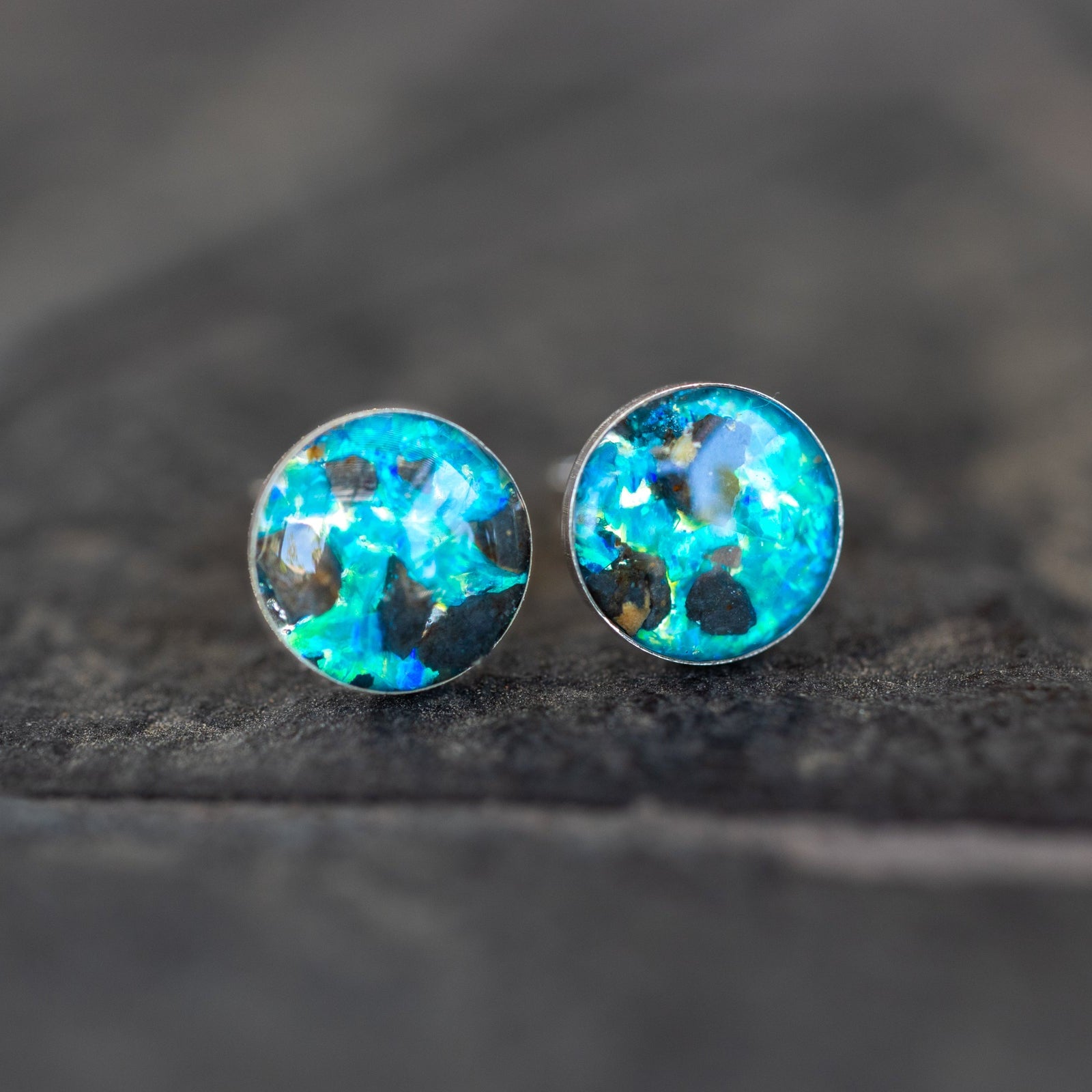 Close-up of the Lunar Blue Studs moon earrings showing a real piece of the Moon set with vivid blue opal in sterling silver