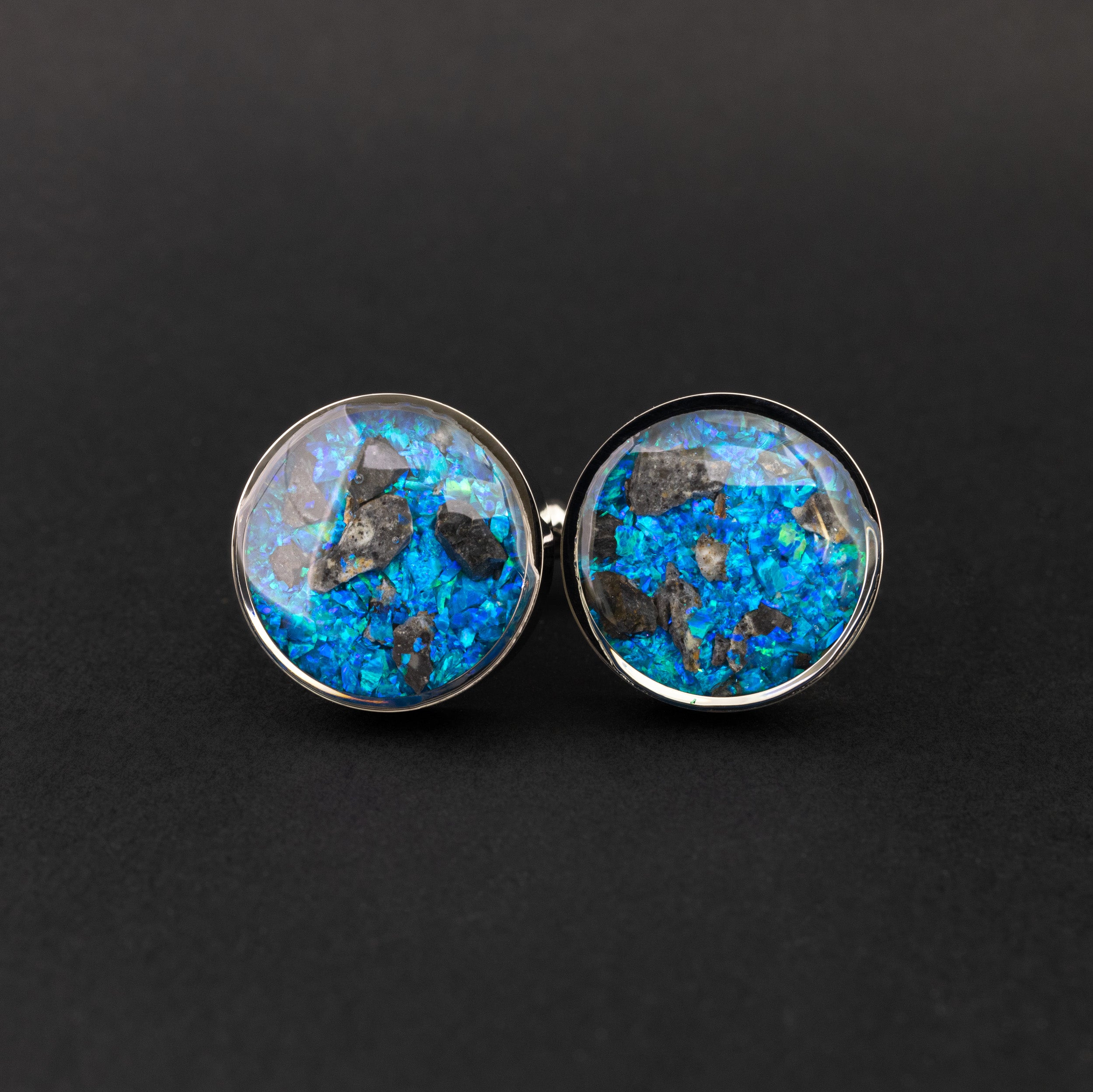 Close-up of the Lunar Meteorite Cufflinks showing a real piece of the Moon set with vivid blue opal in polished silver-tone stainless steel