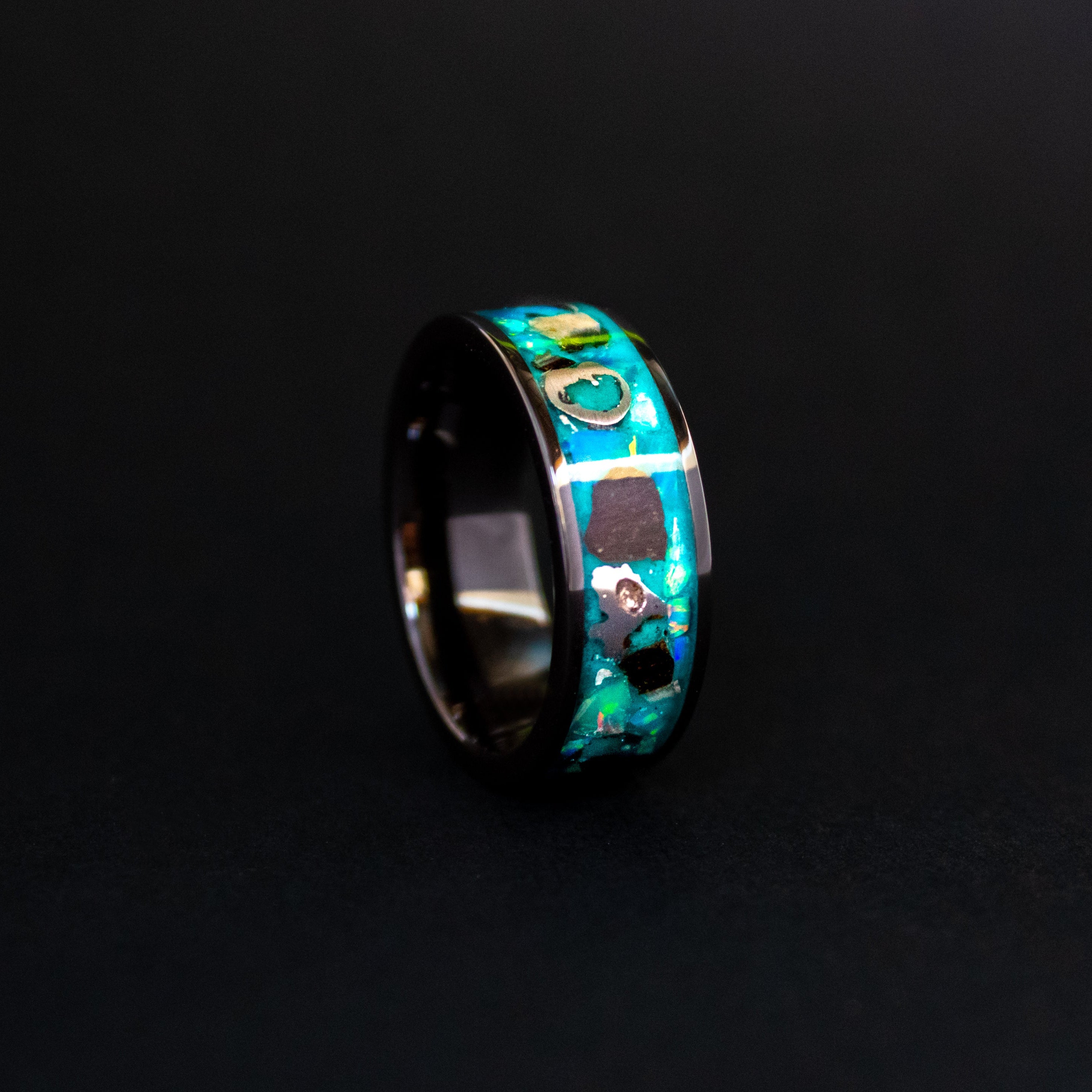 Close up of large genuine Megalodon shark tooth pieces and Campo del Cielo meteorite chunks surrounded by oasis opal inlay on wide channel tungsten ring