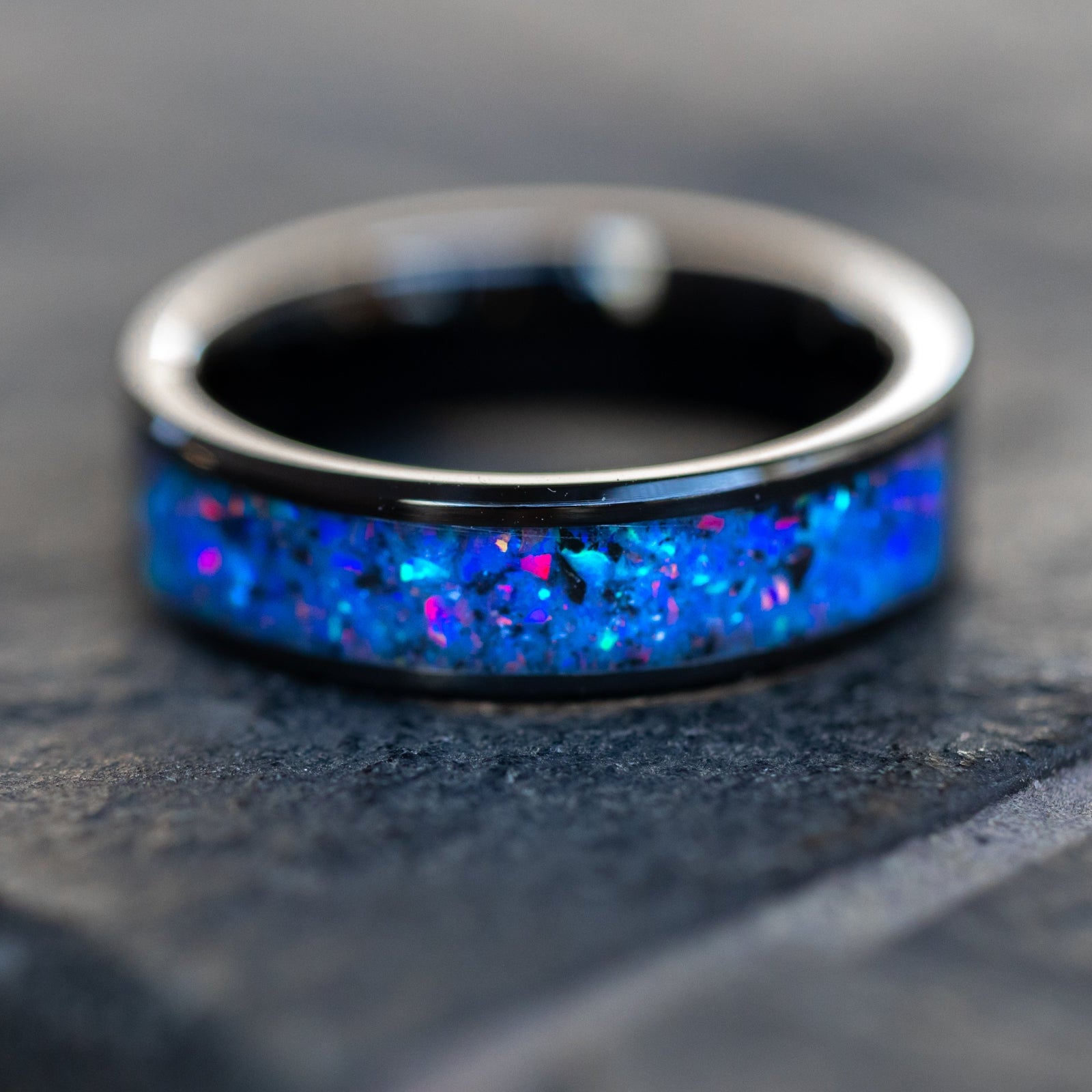 Midnight Megalodon Glow ring glowing blue in total darkness showing Megalodon tooth fossil and meteorite suspended in electric blue glow in the dark inlay