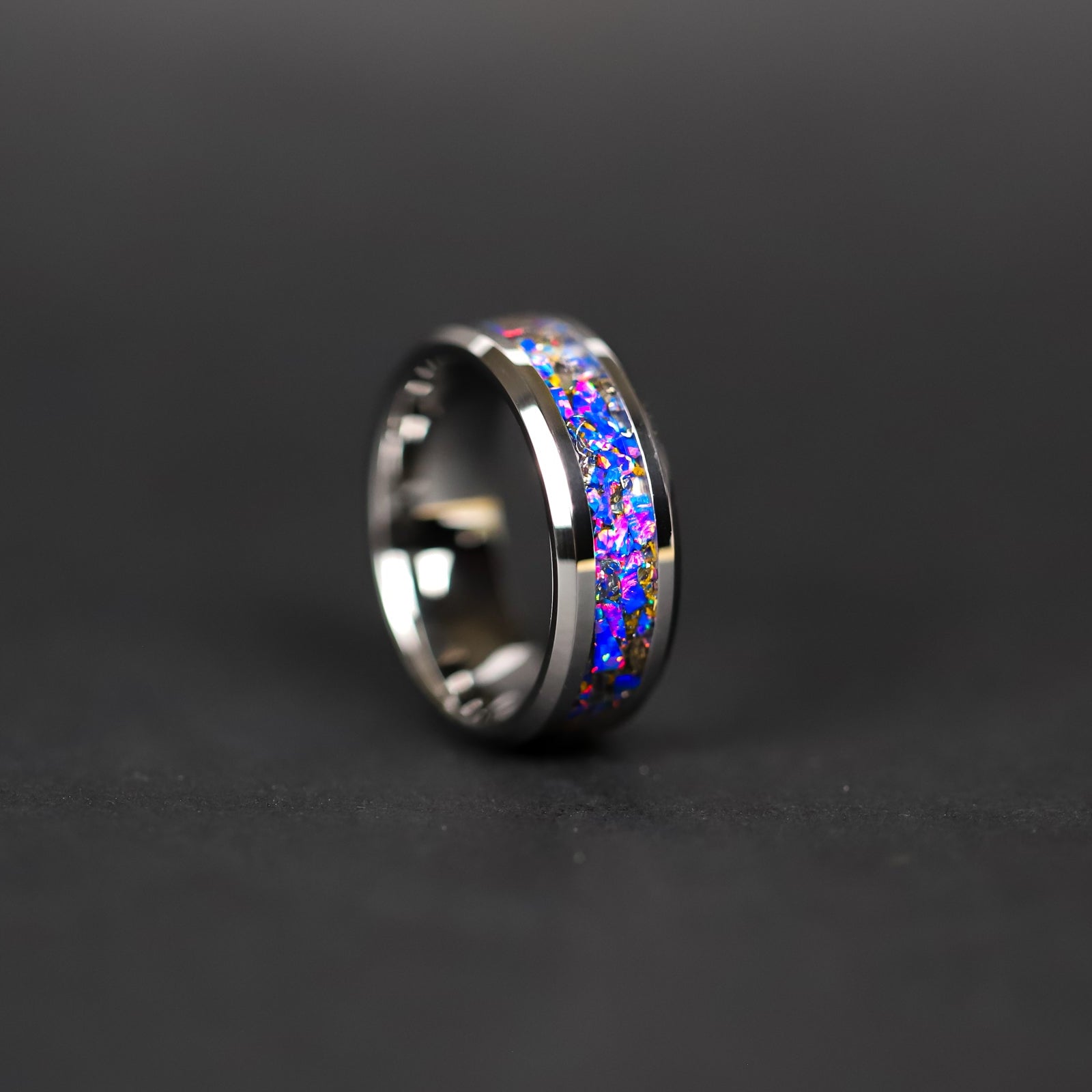 Detail shot of the Midnight Triceratops ring showing authentic Triceratops bone fragments and meteorite shavings catching light through midnight blue purple opal inlay