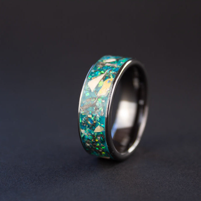 8mm wide channel black ceramic ring with authentic Mosasaur bone and Campo del Cielo meteorite in oasis opal inlay glowing blue in the dark