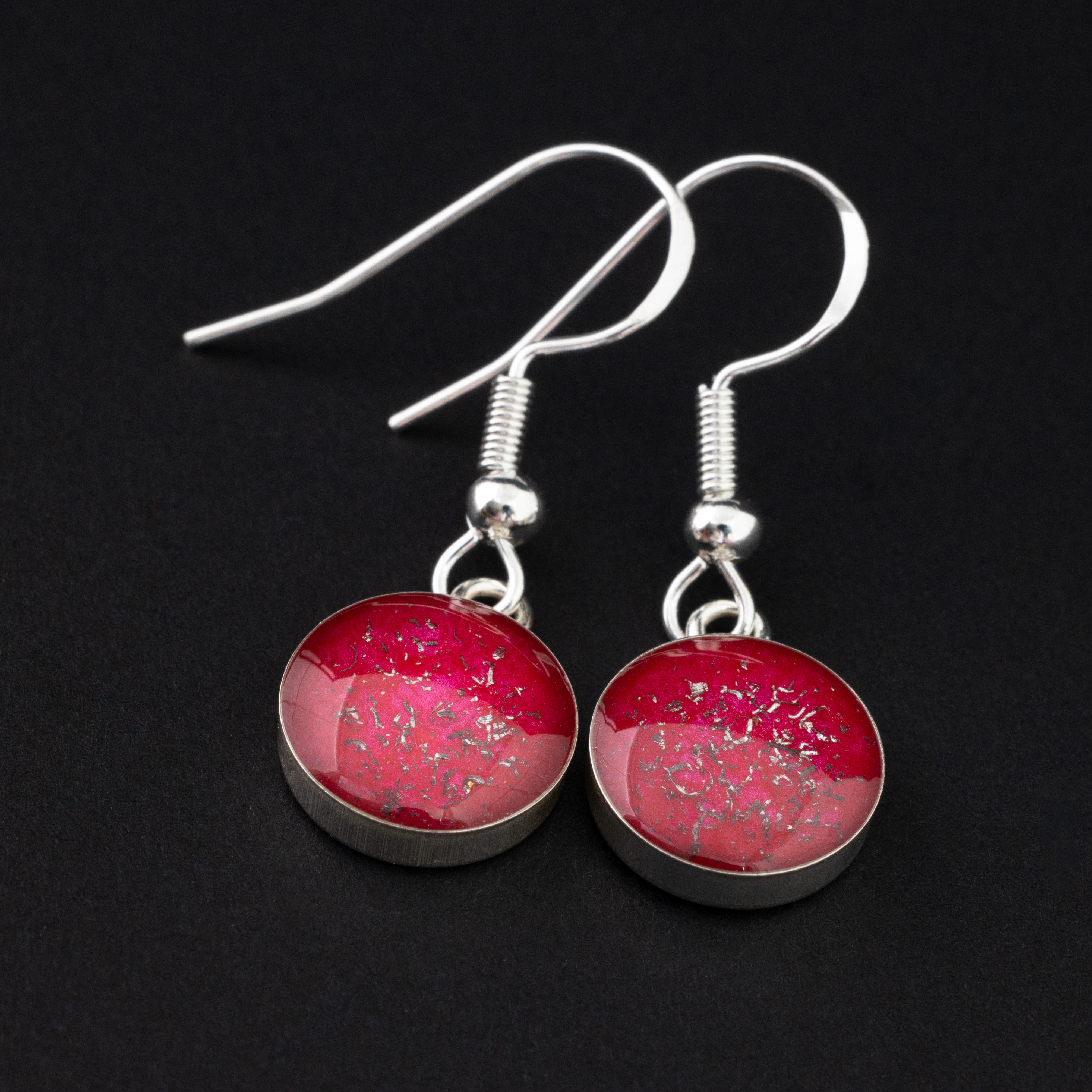 Close-up of the Ruby Dangle red drop earrings showing Campo Del Cielo iron meteorite set in deep ruby red resin with sterling silver French hook ear wires
