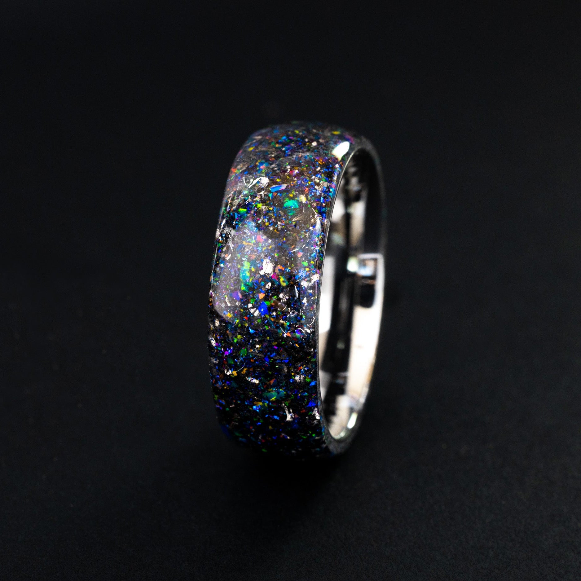 Close up of meteorite shavings in a seamless silver tungsten ring with purple and blue shimmer.