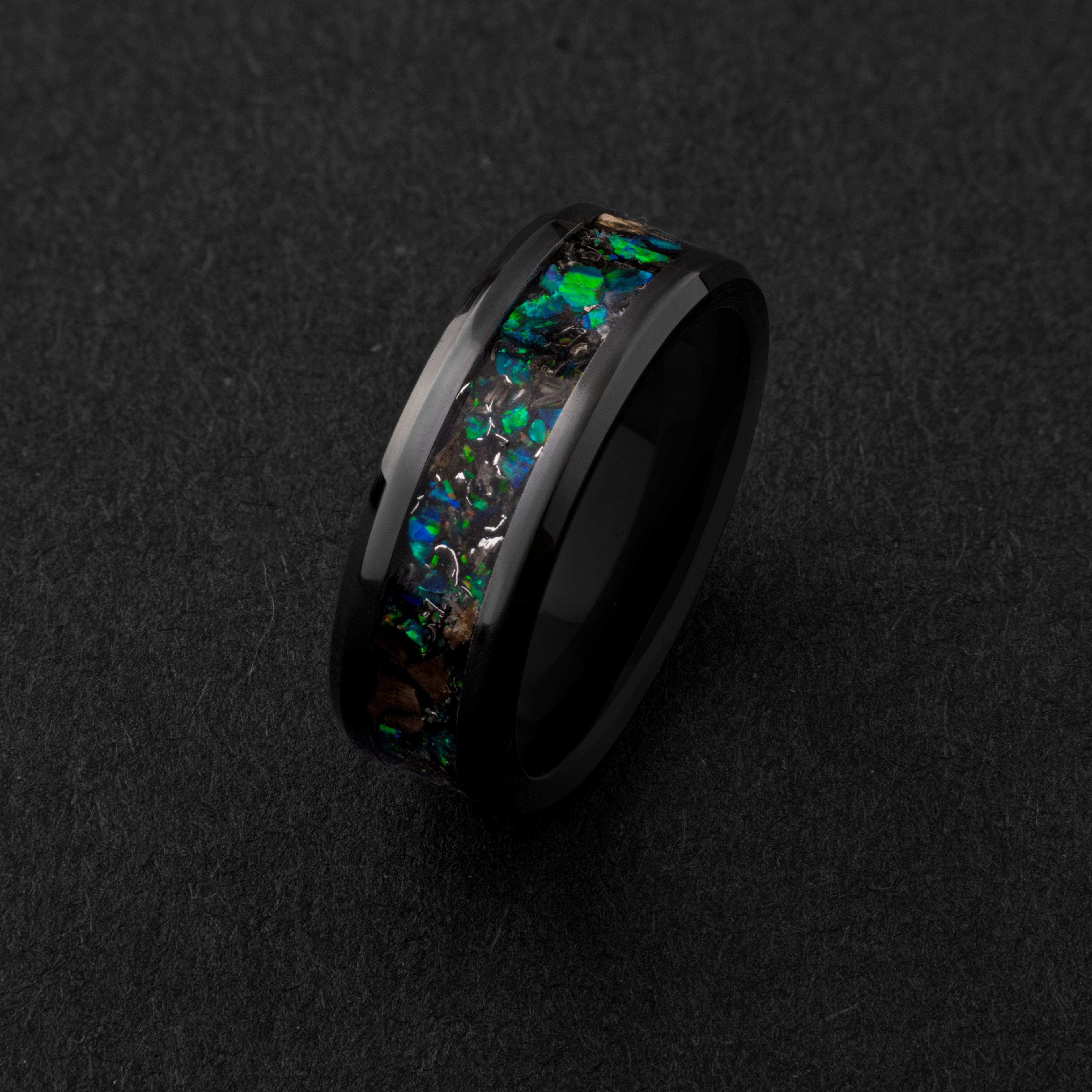 Close up of genuine T-Rex fossil and Campo del Cielo meteorite shavings suspended in green opal inlay on beveled black ceramic ring