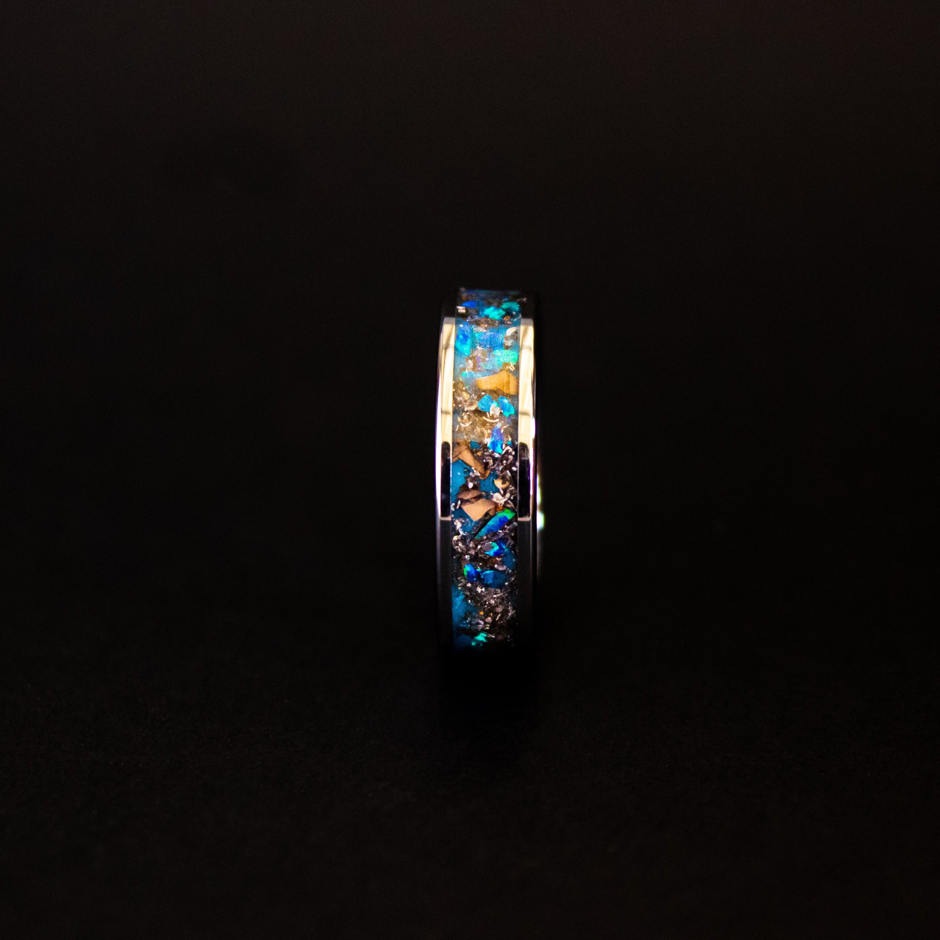 Triceratops Blue Glow ring glowing blue in total darkness showing Triceratops bone and meteorite suspended in electric blue glow in the dark inlay