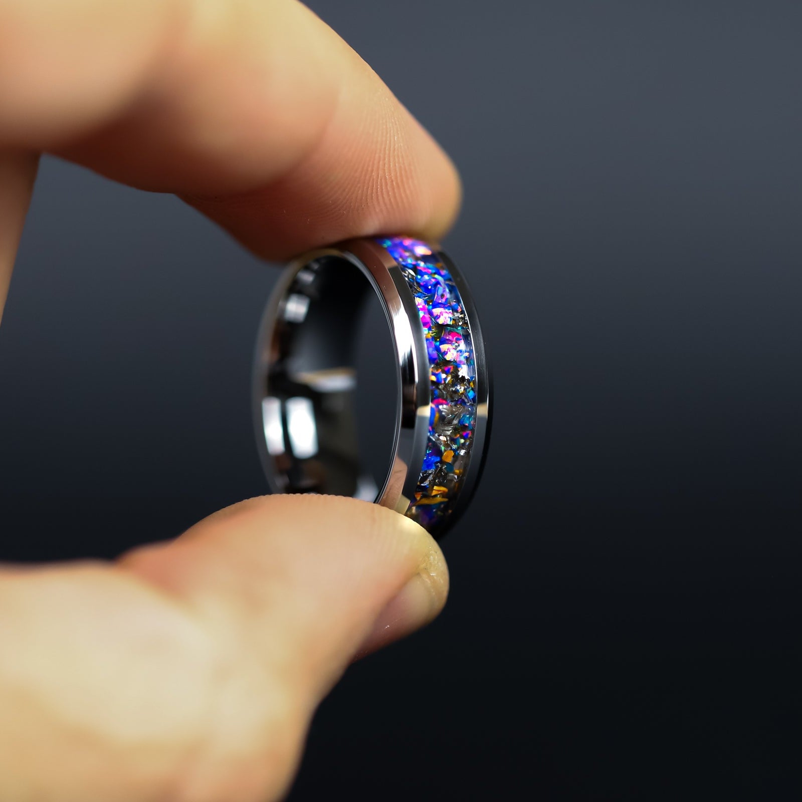Close up of genuine Triceratops fossil and Campo del Cielo meteorite shavings suspended in midnight opal inlay on beveled tungsten ring