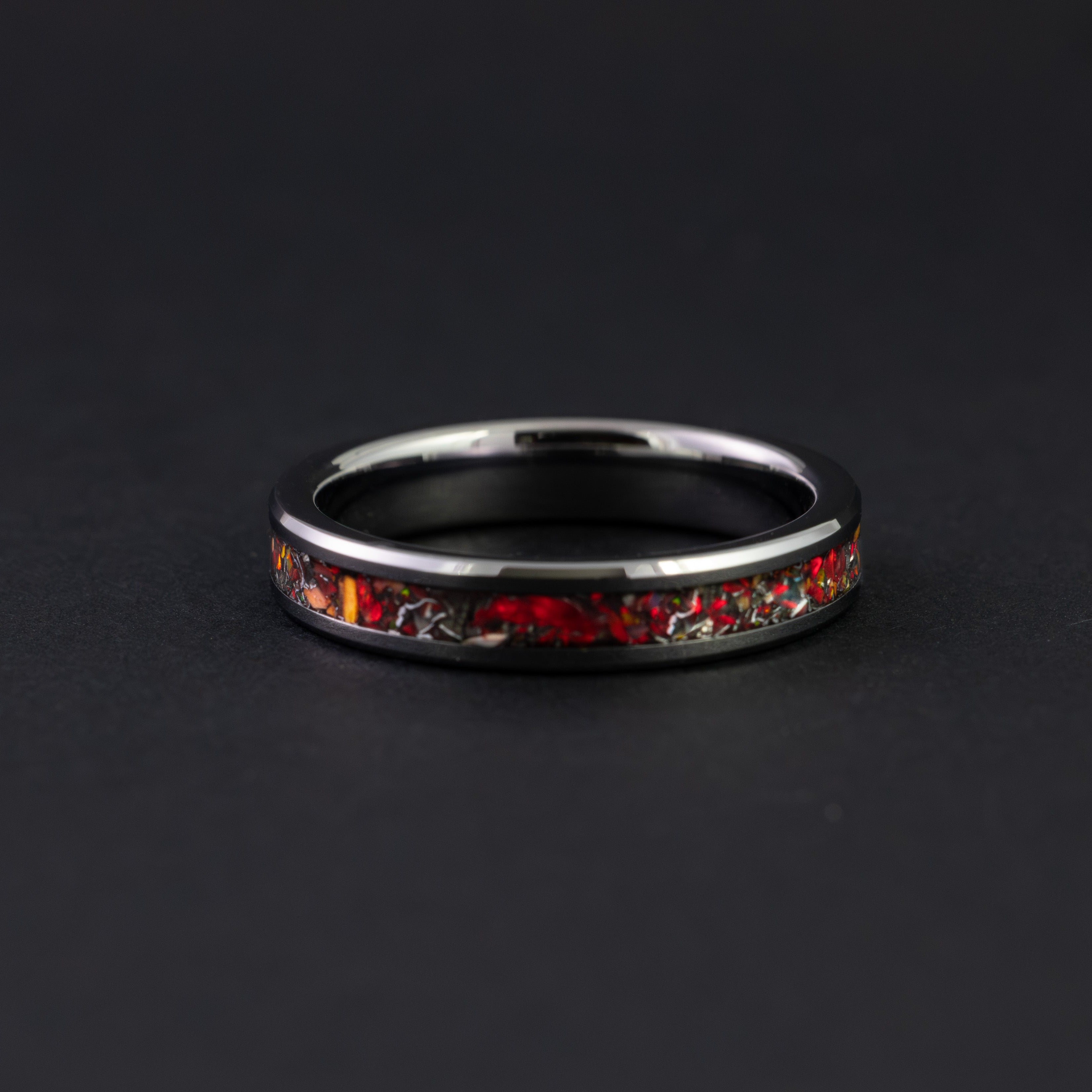 Thin 4mm beveled black ceramic ring featuring authentic meteorite and vibrant red opals.