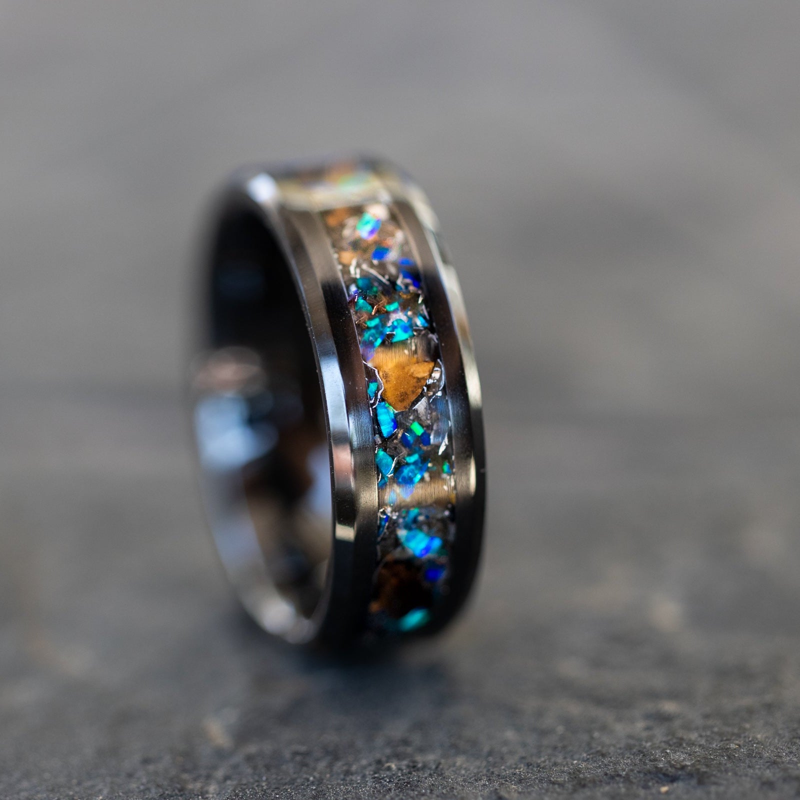 Handcrafted 8mm beveled black ceramic mens wedding band with authentic Velociraptor bone and Campo del Cielo meteorite in blue opal inlay made in California