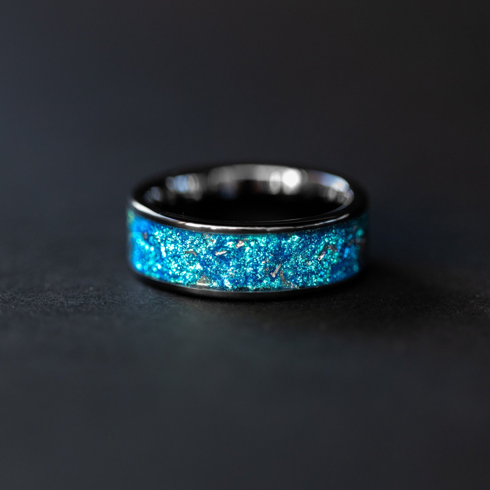 Handcrafted 8mm wide channel black ceramic mens wedding band with authentic Campo del Cielo meteorite in blue glitter pigment inlay made in California