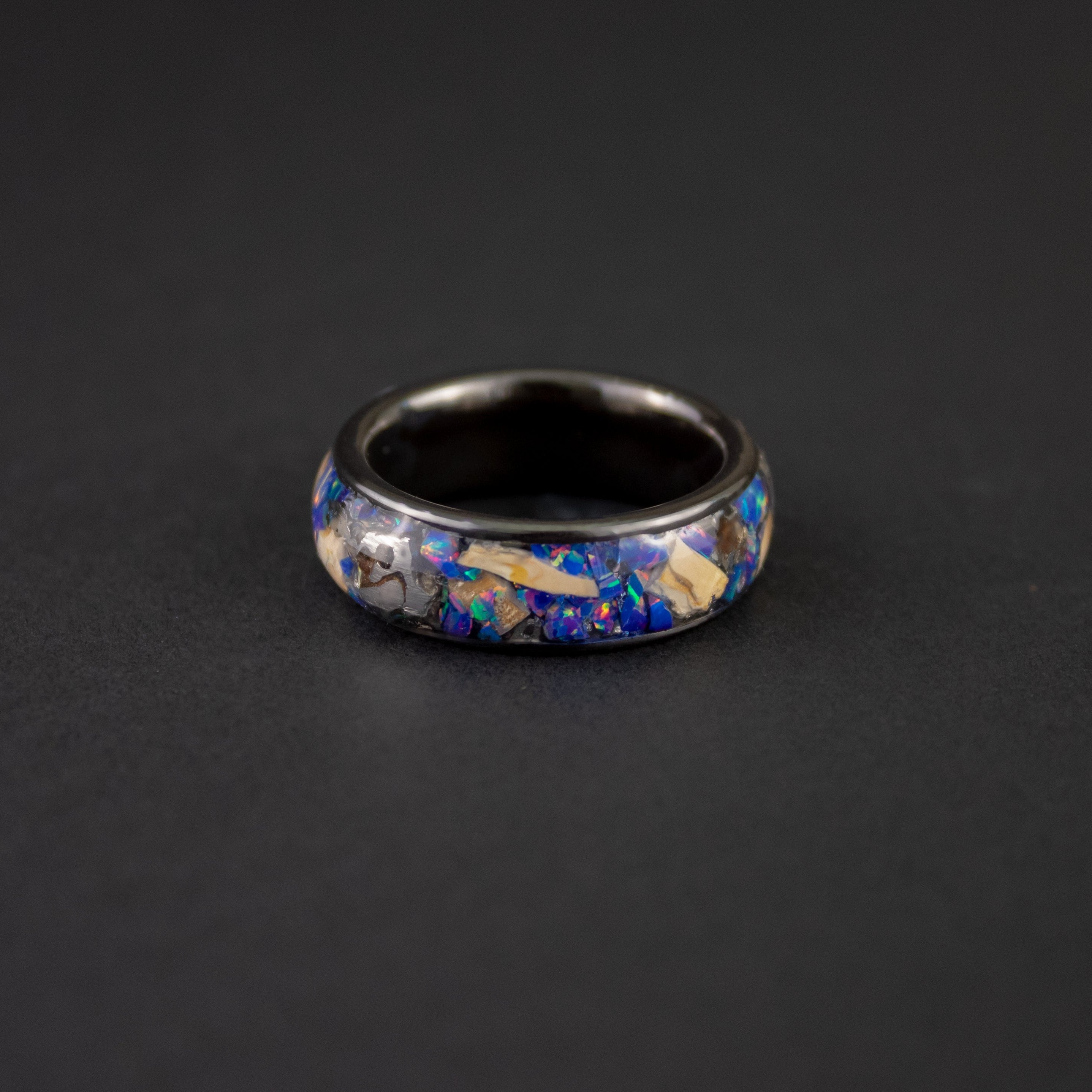 Handcrafted 8mm wide channel black ceramic mens wedding band with large authentic Mosasaur bone and Campo del Cielo meteorite pieces in midnight opal inlay made in California