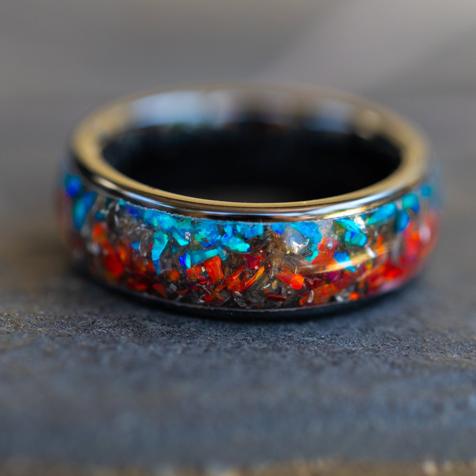 Handcrafted 8mm wide channel black ceramic mens wedding band with authentic Campo del Cielo meteorite in split red and blue opal inlay made in California