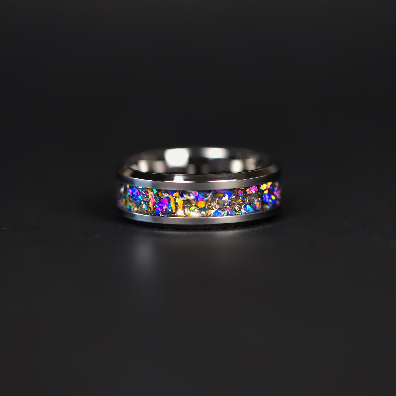 Detail shot of the Midnight Triceratops ring showing authentic Triceratops bone fragments and meteorite shavings catching light through midnight blue purple opal inlay
