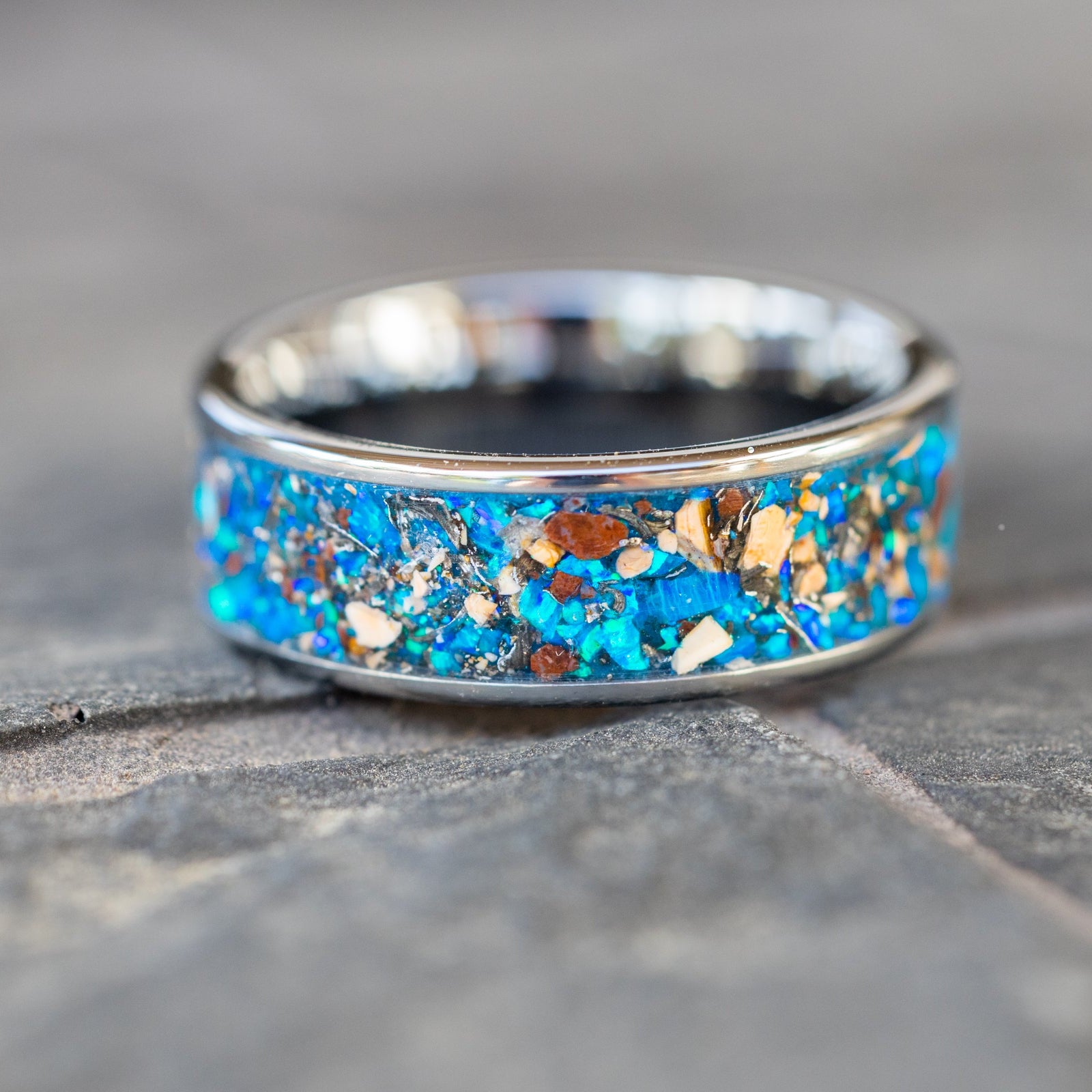 Handcrafted 8mm wide channel tungsten mens wedding band with authentic Mosasaur bone, Dinosaur Gembone, and Campo del Cielo meteorite in blue opal blue glow inlay made in California