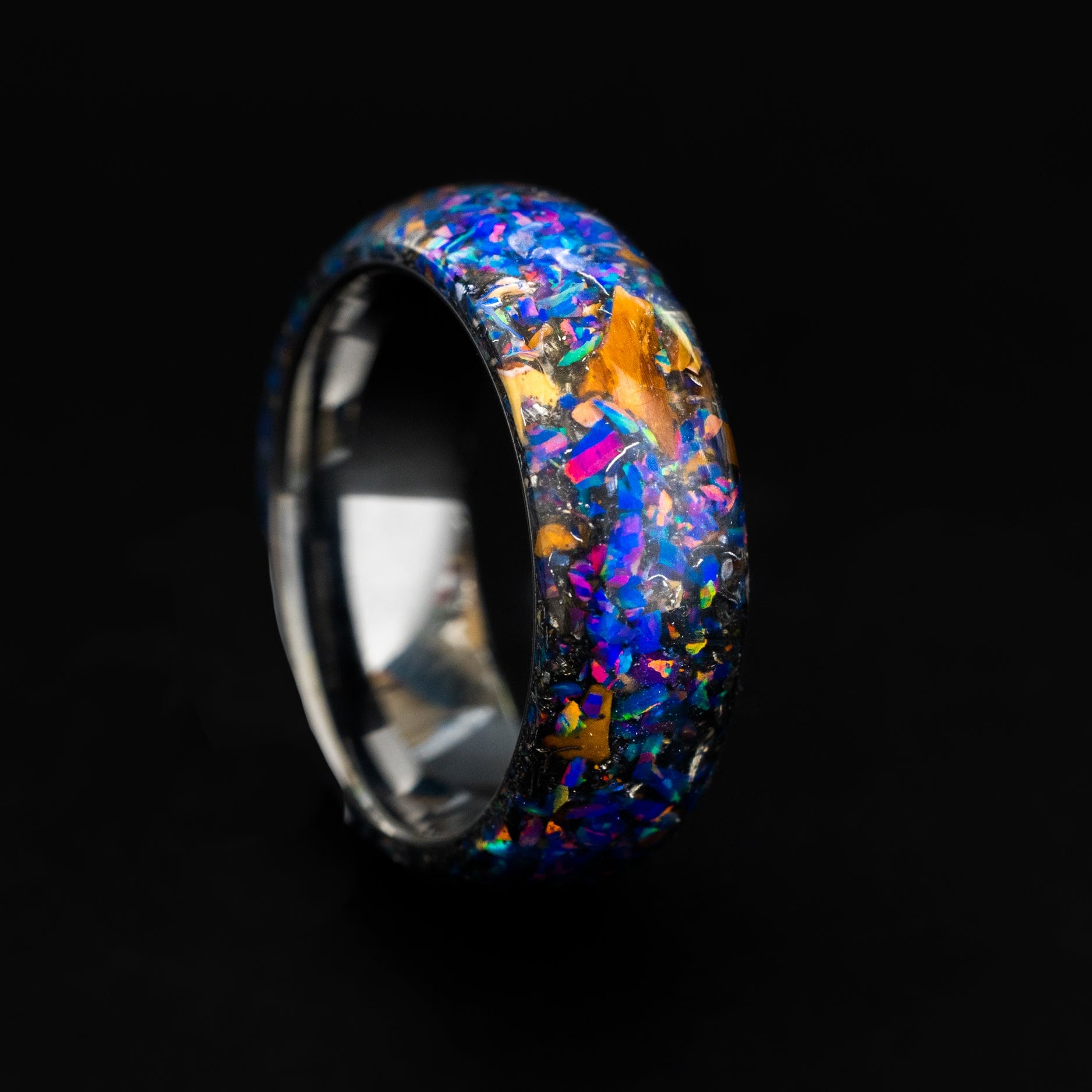 Close up of dinosaur bone and midnight purple opals in a seamless silver tungsten ring.