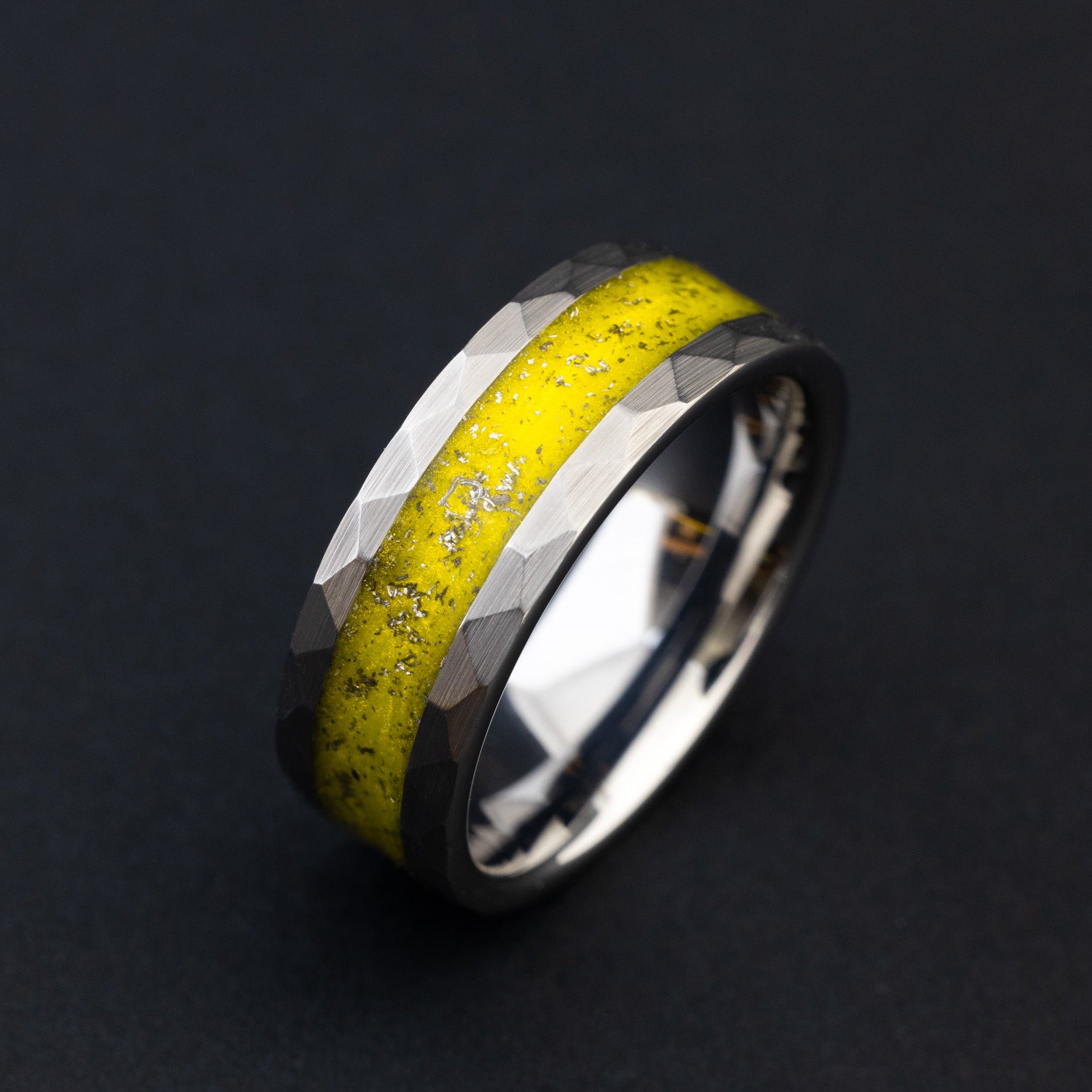 Close up of Gibeon meteorite shavings in a bright yellow hammered tungsten ring.