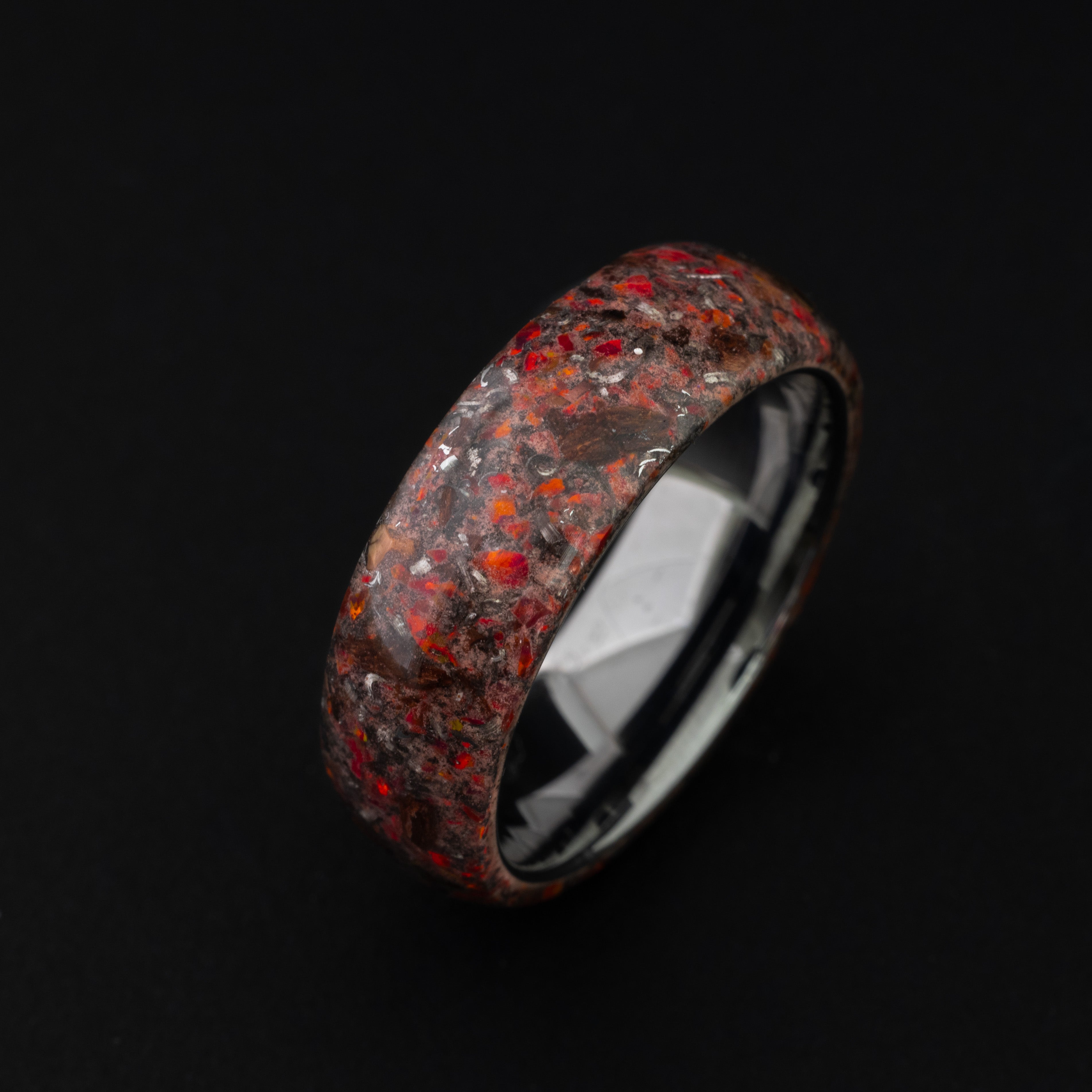 Close up of genuine T-Rex bone and Campo meteorite shavings in a red glowing 360-degree wrap ring.