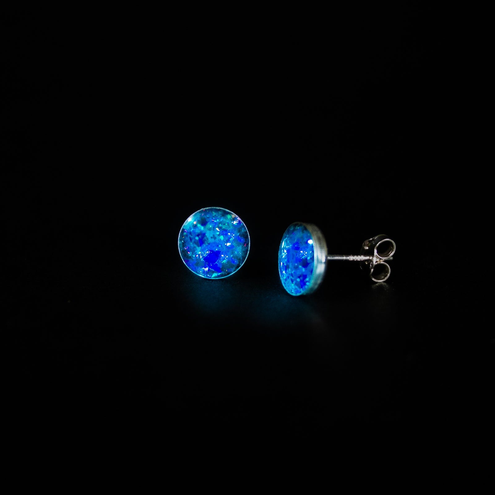 Megalodon Glow Studs authentic silver stud earrings with real megalodon shark tooth, Campo Del Cielo meteorite, blue and purple opal, and blue glow in the dark pigment