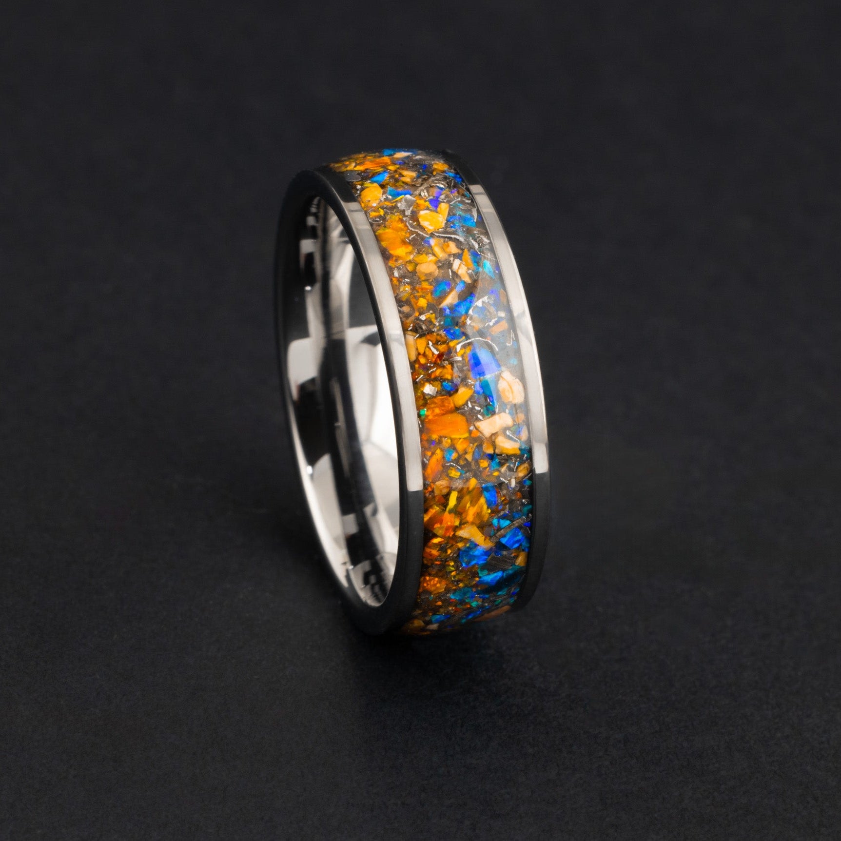 Handcrafted Velociraptor bone and meteorite ring with vibrant blue and orange opal inlay.
