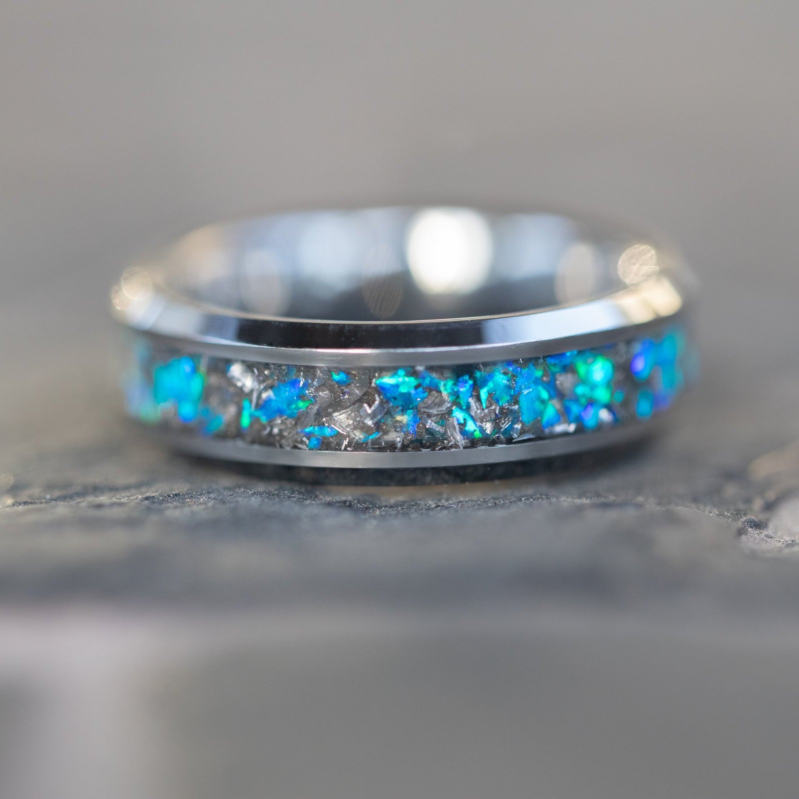 Detail shot of the Blue Orbit ring showing authentic Campo del Cielo meteorite shavings catching light through deep blue opal inlay