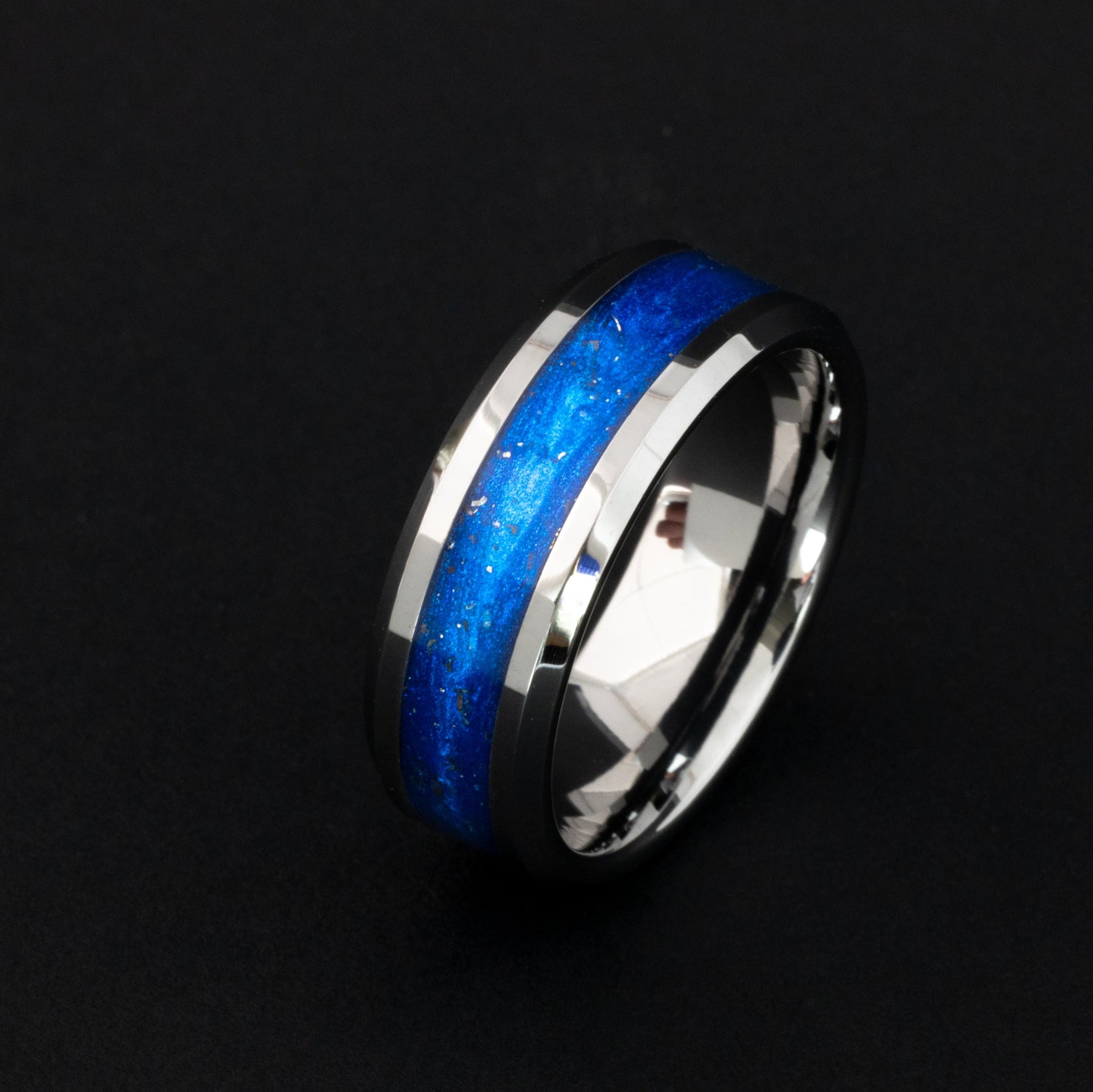 Close up of Campo del Cielo meteorite shavings in a deep blue 8mm beveled tungsten ring