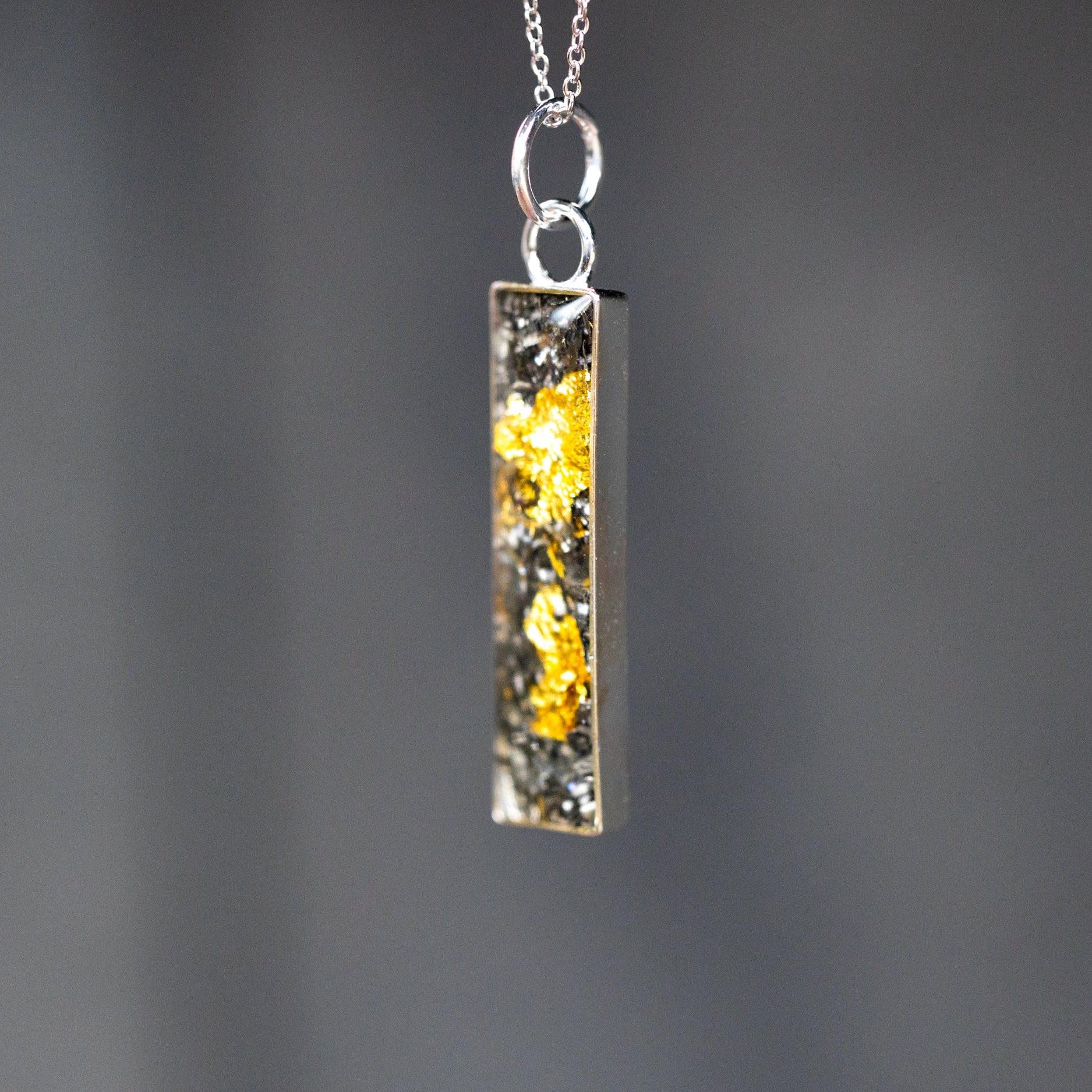 Close-up of the Bullion Bar Silver gold and silver necklace showing Campo Del Cielo iron meteorite fragments set with real 24K gold flake