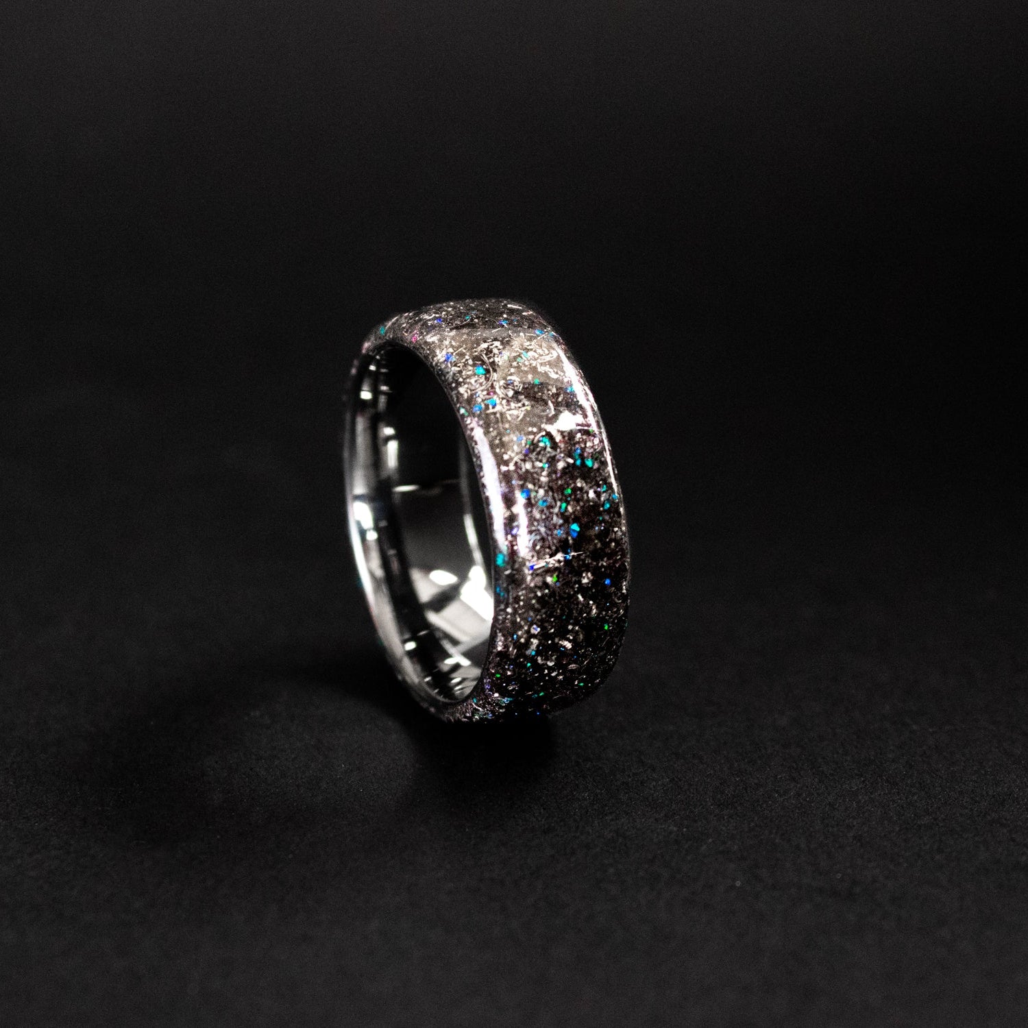 Close up of genuine Campo del Cielo meteorite shavings with scattered blue opal accents on endless tungsten ring