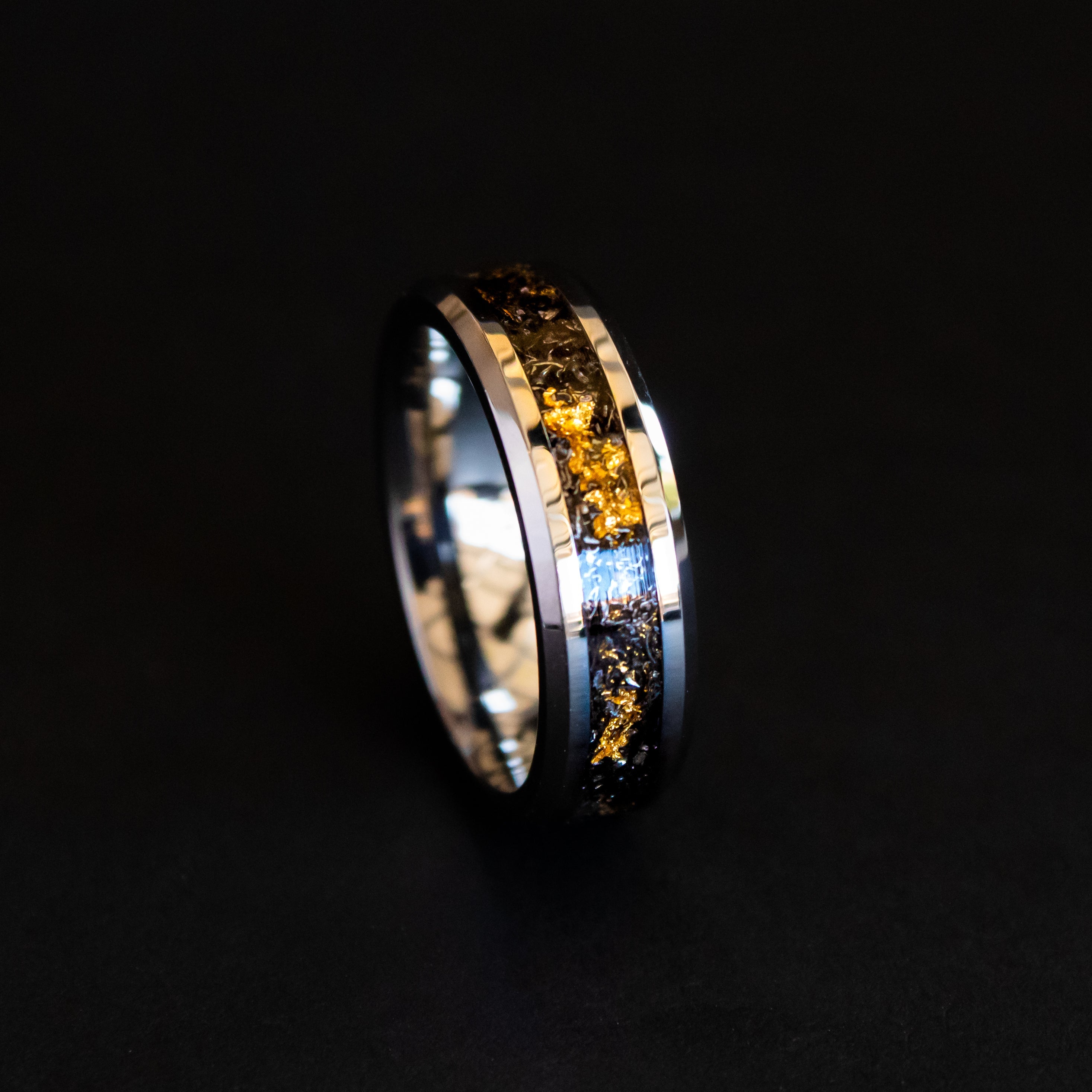Close up of genuine Campo del Cielo meteorite shavings mixed with real gold metal flake inlay on 6mm beveled tungsten ring
