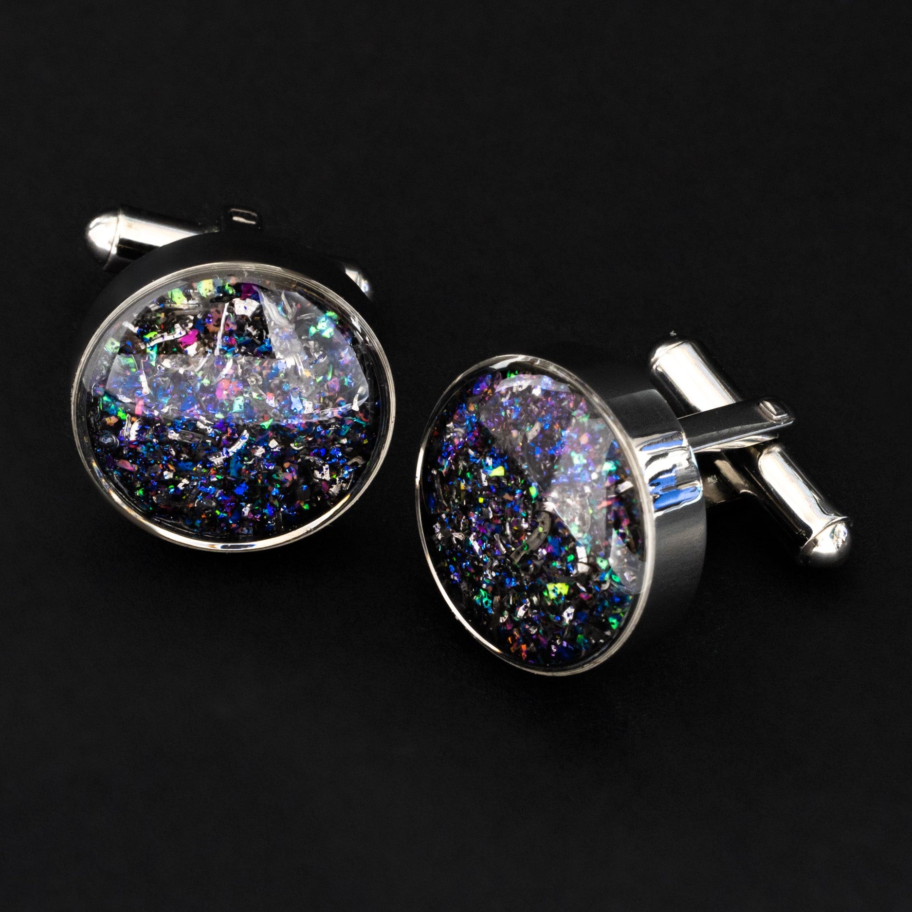 Close-up of the Galaxy Cufflinks showing Campo Del Cielo iron meteorite set with a galaxy-inspired blend of blue, purple, pink, green, and white opals and pigment glitter in polished silver-tone stainless steel