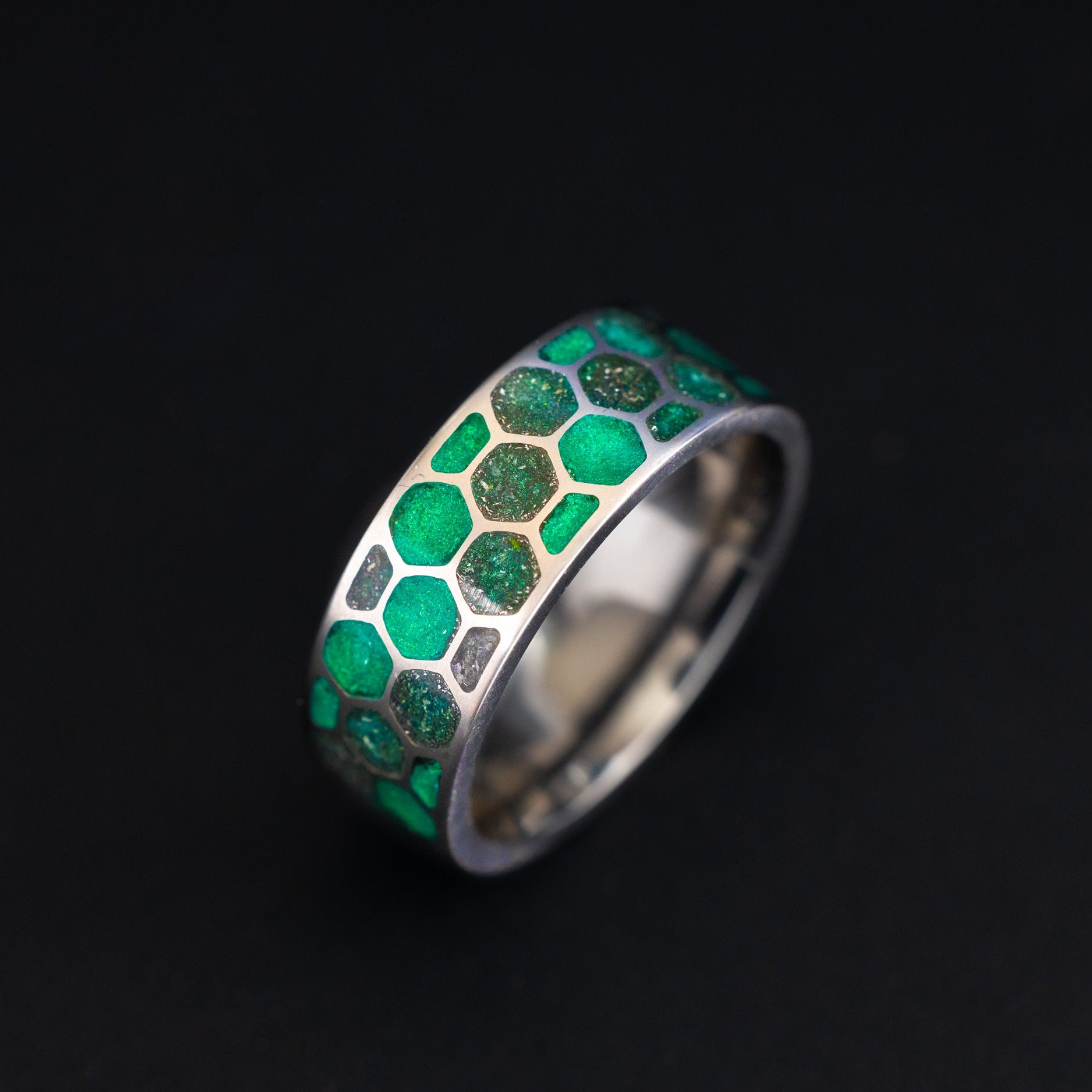 Side profile of the handcrafted titanium Green Hive Glow ring with honeycomb cells made in a California studio.