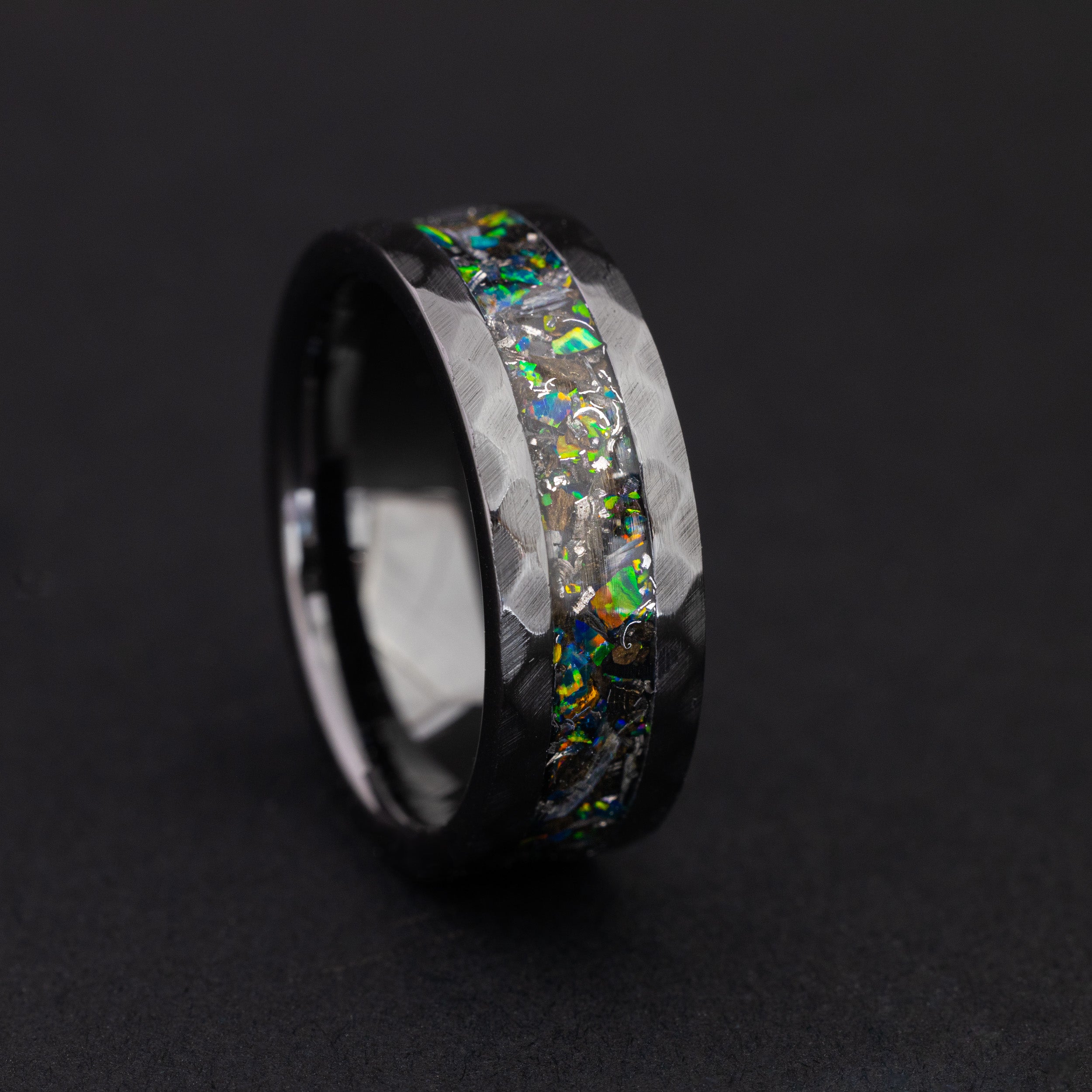 Close up of genuine Megalodon fossil shards and meteorite in a hammered black wedding band.