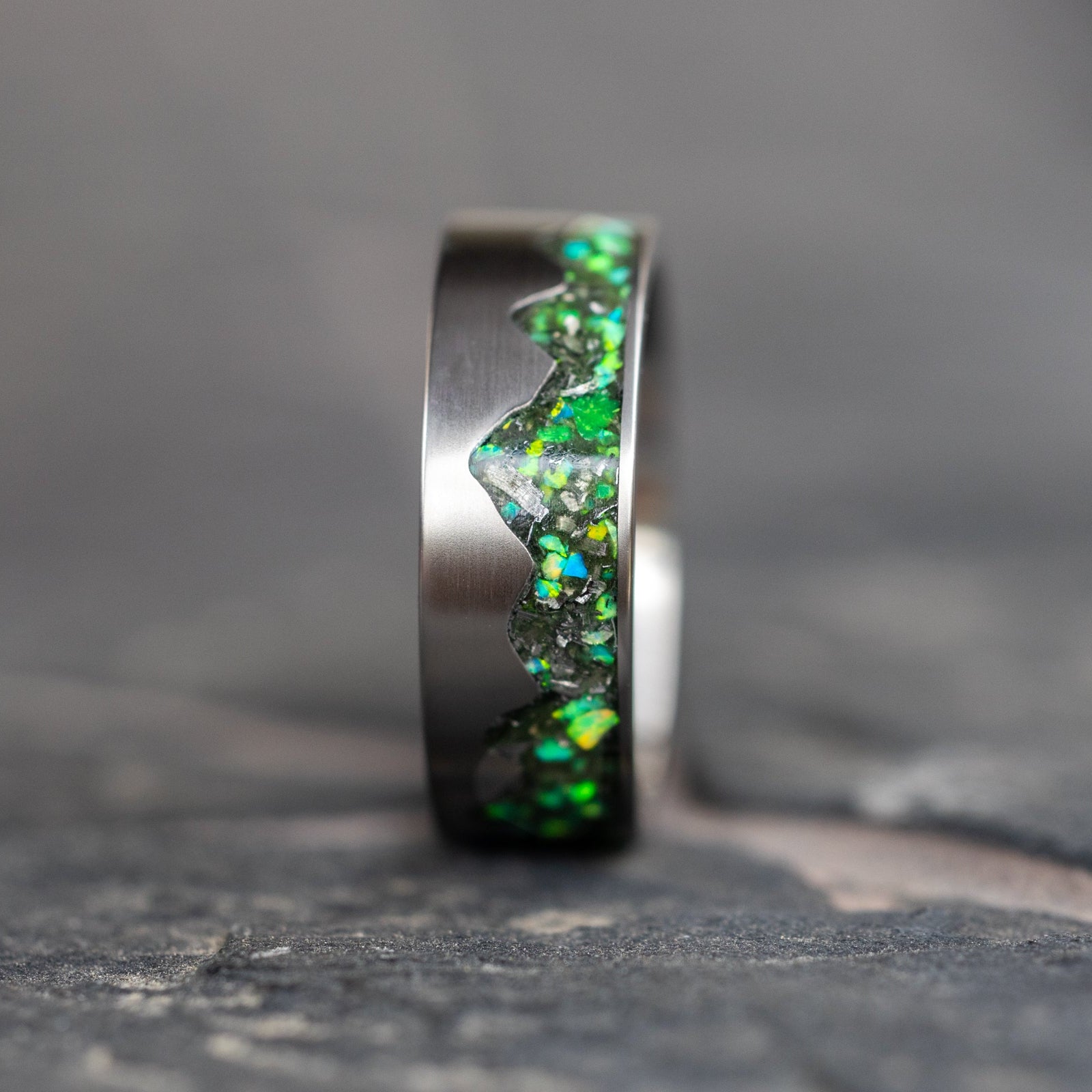 Close-up of the Green Ridgeline ring showing Campo Del Cielo meteorite fragments in vibrant green opal.