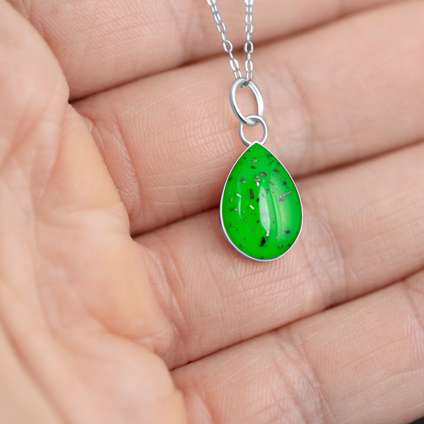 Handcrafted sterling silver teardrop pendant with meteorite and lime green resin inlay shown from the front