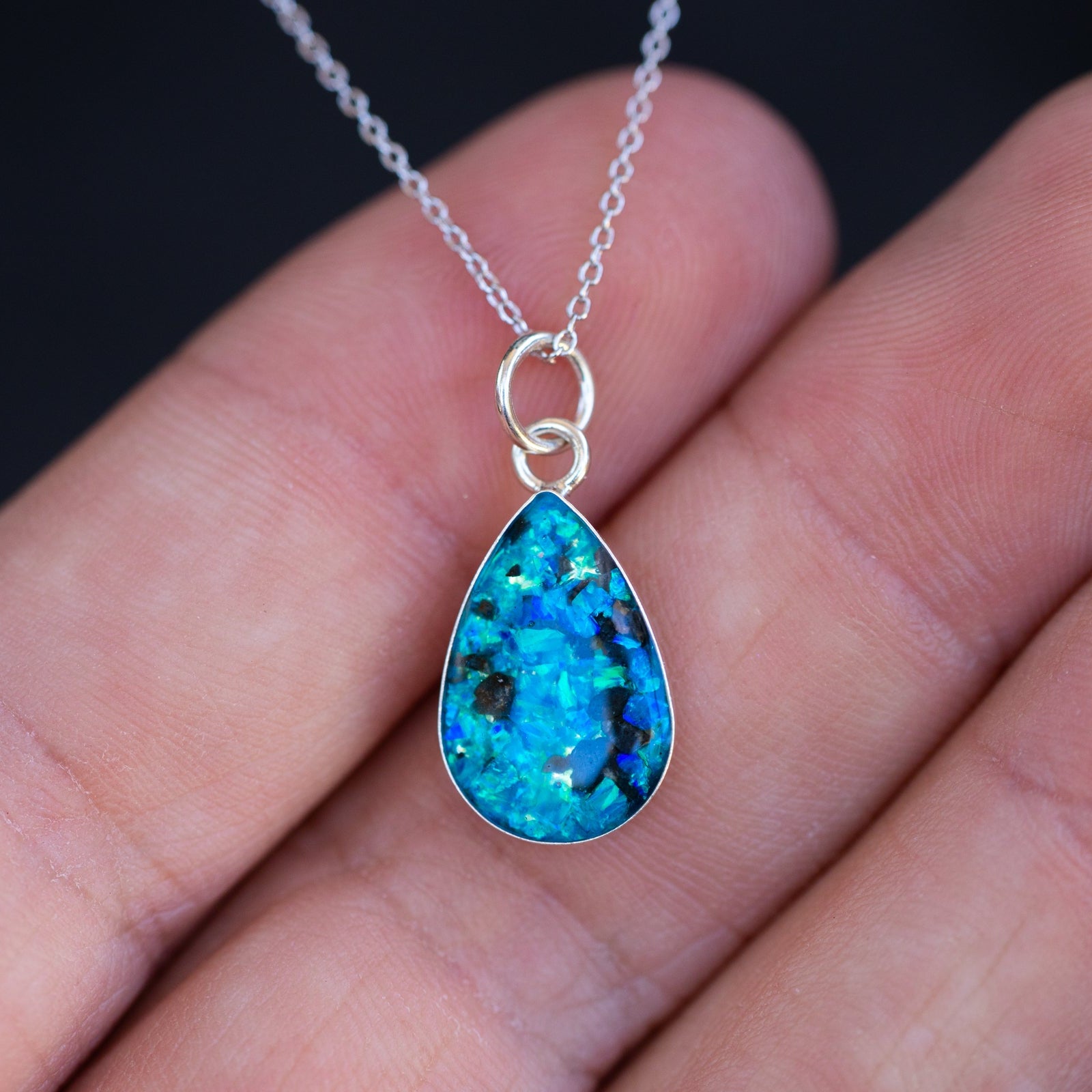 Close-up of the Lunar Blue Drop moon necklace showing a real piece of the Moon set with vivid sky blue opal in sterling silver