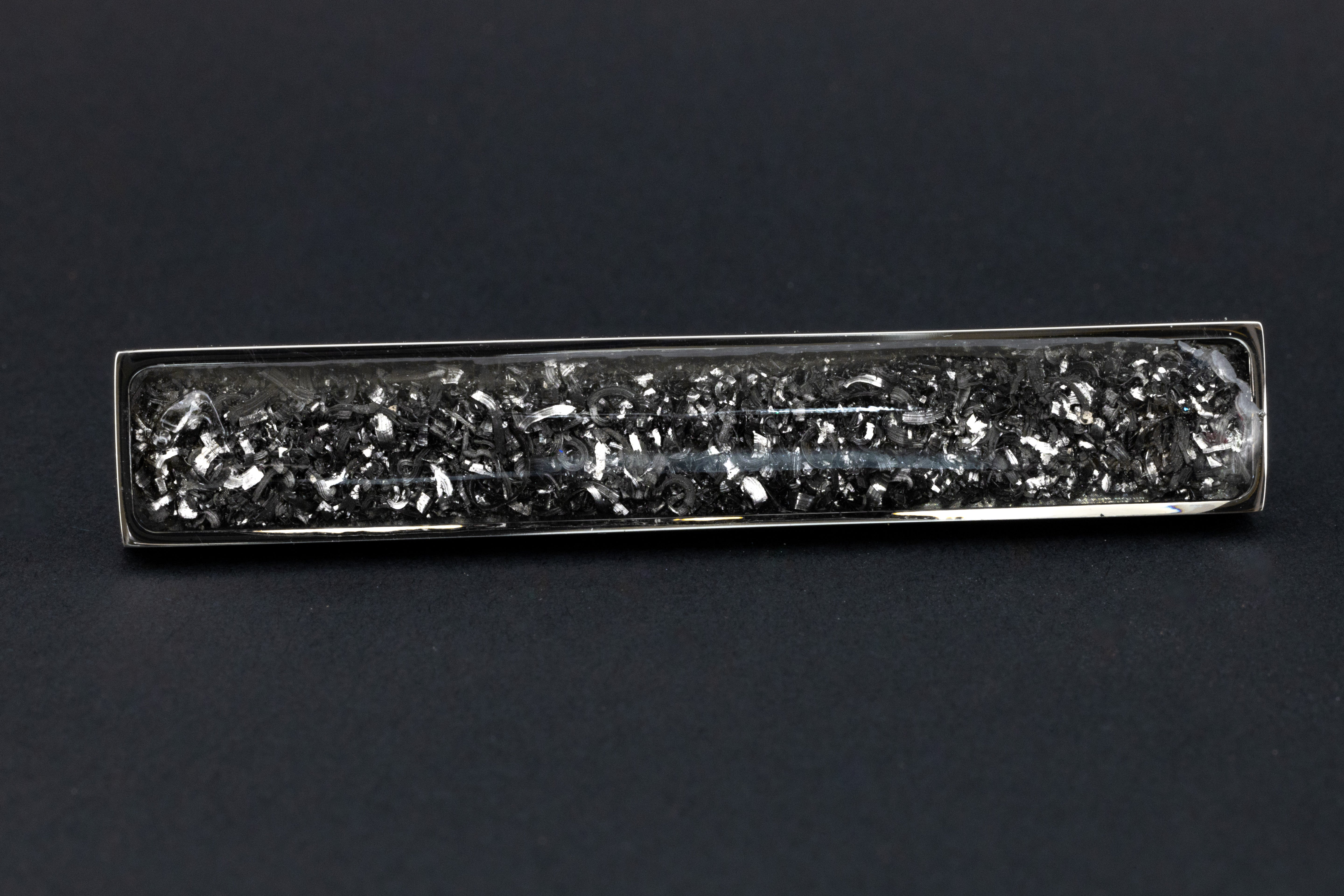 Close-up of the Meteorite Tie Clip showing real Campo Del Cielo iron meteorite set in polished silver-tone stainless steel