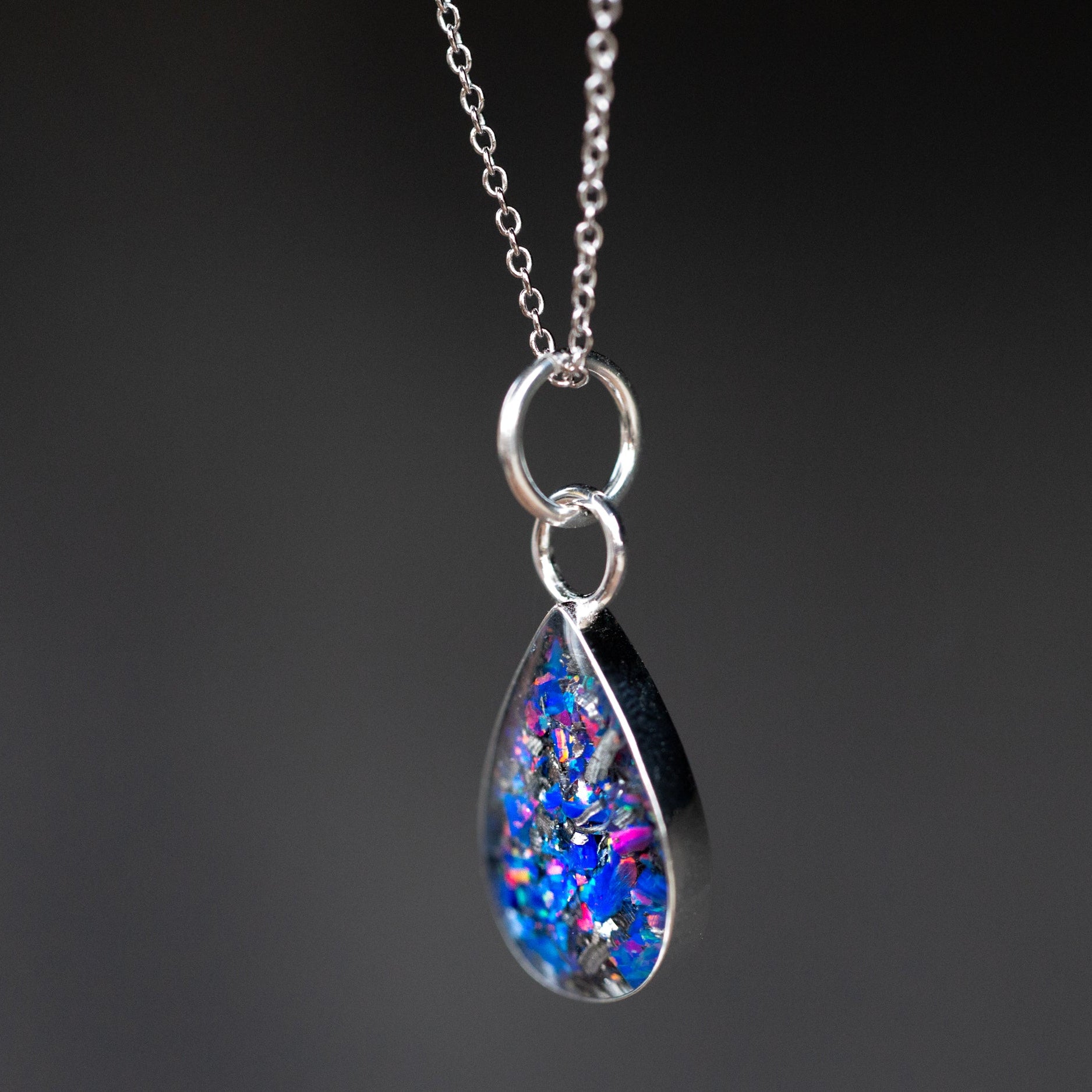Close-up of the Midnight Opal Drop showing Campo Del Cielo iron meteorite fragments set with deep purple and blue Midnight Opal evoking a midnight sky